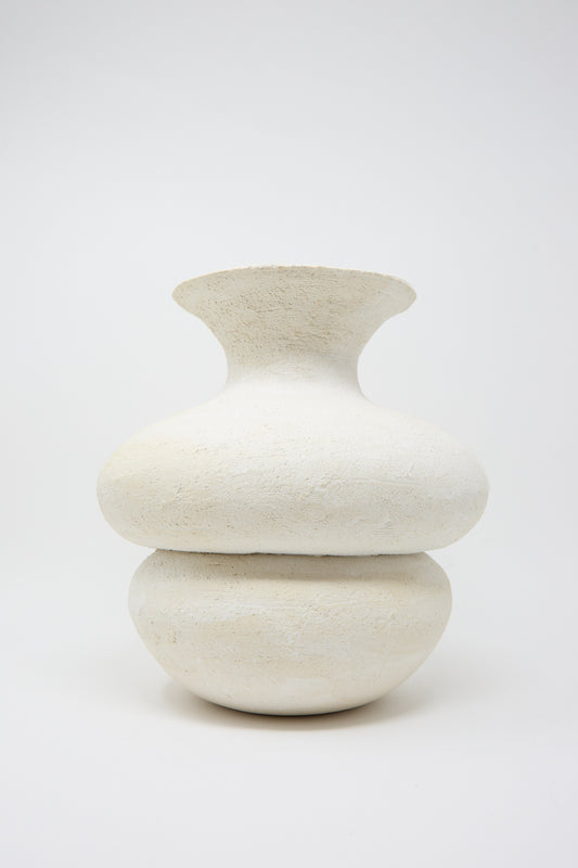 Crafted by Oatmeal in Pennsylvania, the Double Bottom Vessel is a white, textured ceramic piece with a wide, round base and narrow neck, presented against a plain background.