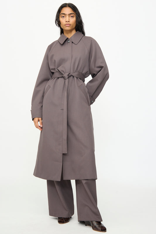 A person wearing the Olivia Cashmore Gordie Coat in Mud, styled over matching wide-leg pants, stands against a plain white background.