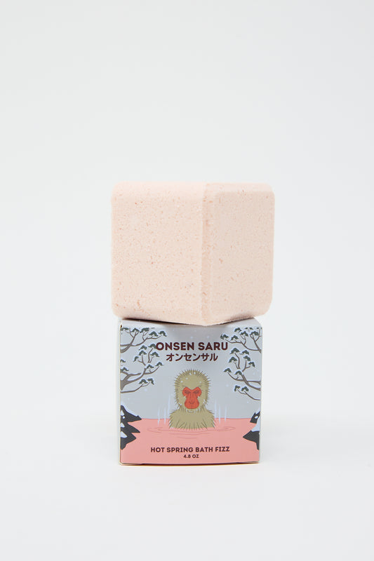 Pink Hot Spring Bath Fizz labeled "Onsen Saru hot spring bath fizz" in a decorated box on a white background, inspired by Japanese bath salts.