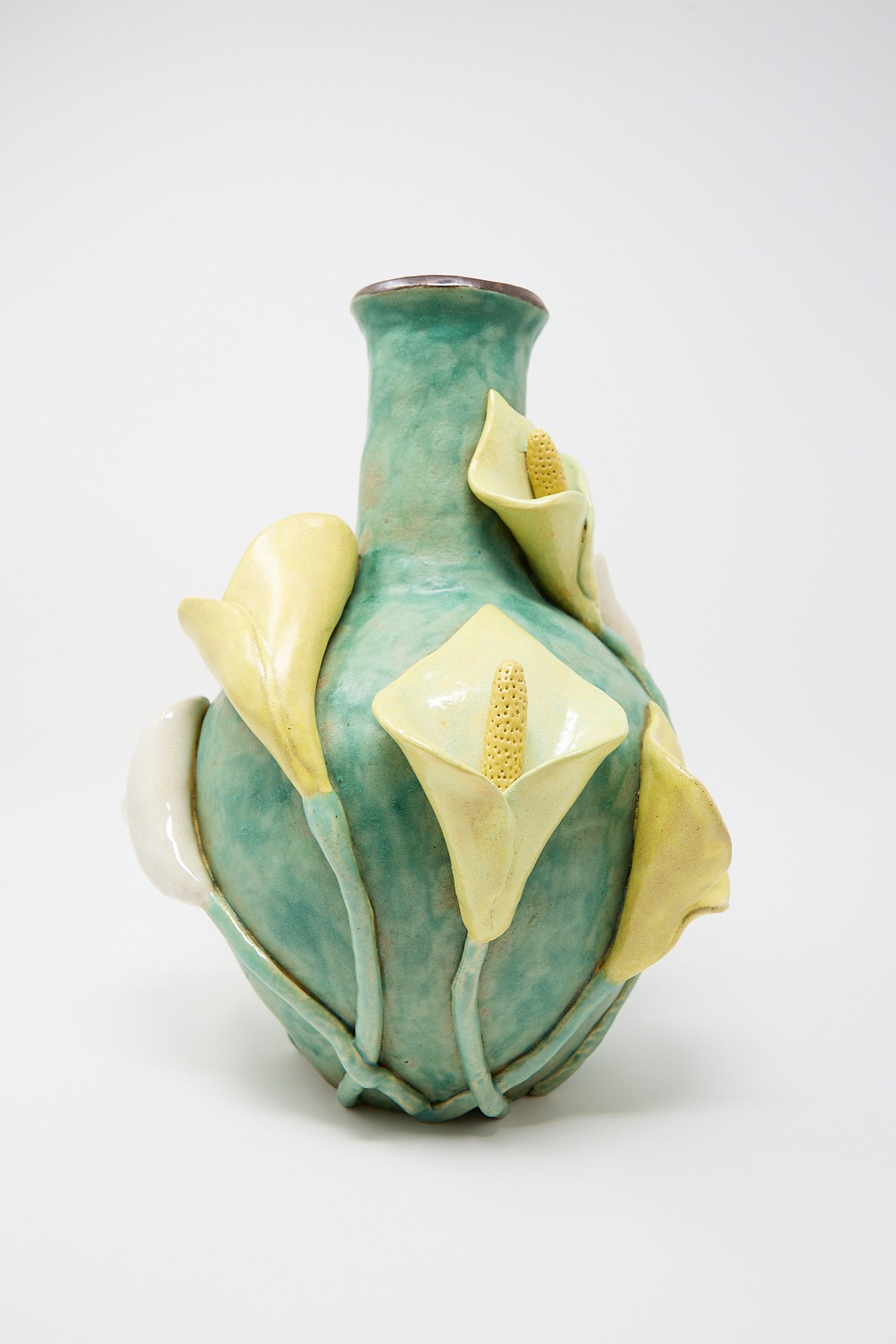 A Pearce Williams ceramic Calla Vase with a turquoise glaze, embellished with sculpted, yellow and white calla lilies on its surface.