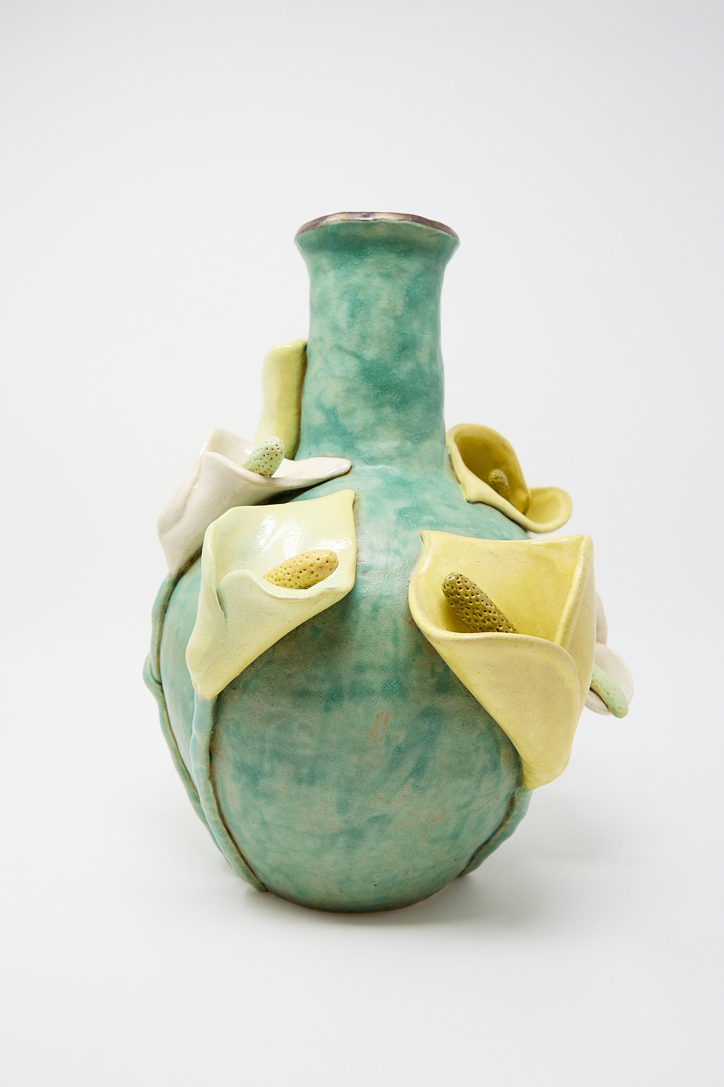 Pearce Williams Calla Vase with a turquoise glaze and decorative, pale yellow calla lilies attached to its surface.