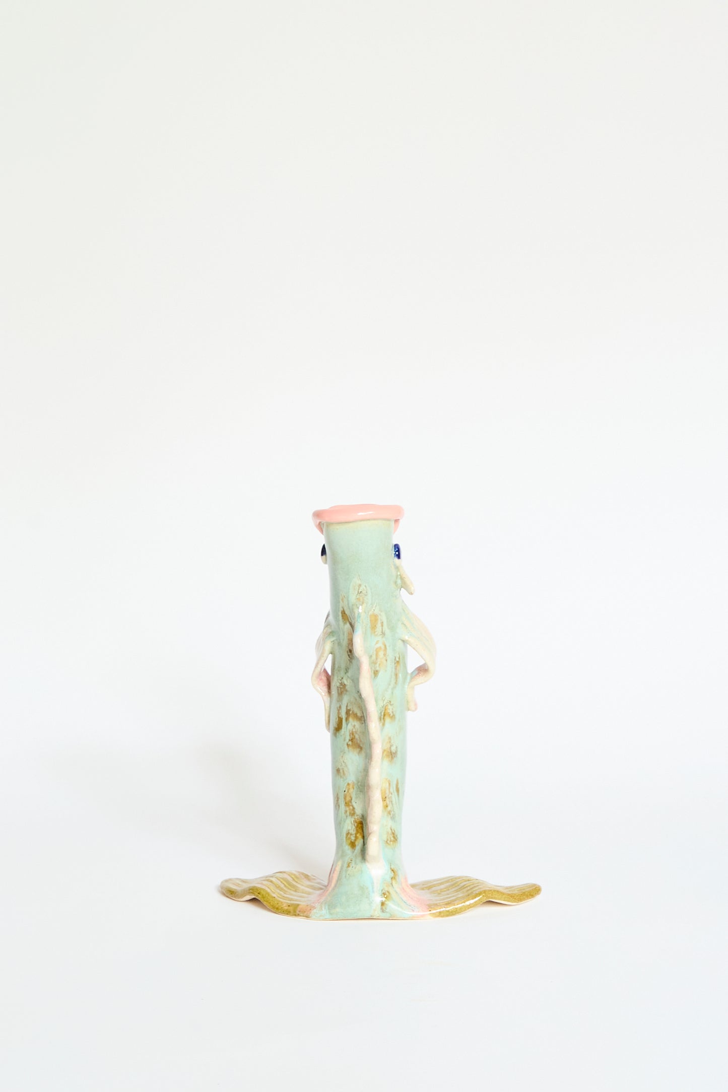 The Fish Vase Small in Green by Pearce Williams is a handmade ceramic sculpture with a vertical fish-shaped design, pastel green tones, and gold-accented fins, showcased against a plain white background.