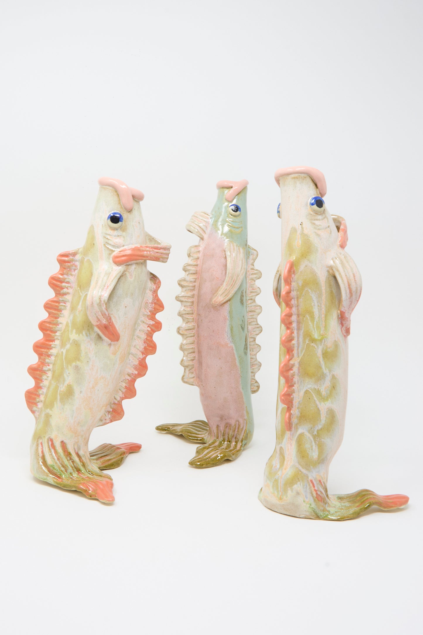 Three Pearce Williams Fish Vase in Coral III ceramics stand upright on a white background, each with textured scales and pink, green, and orange accents.