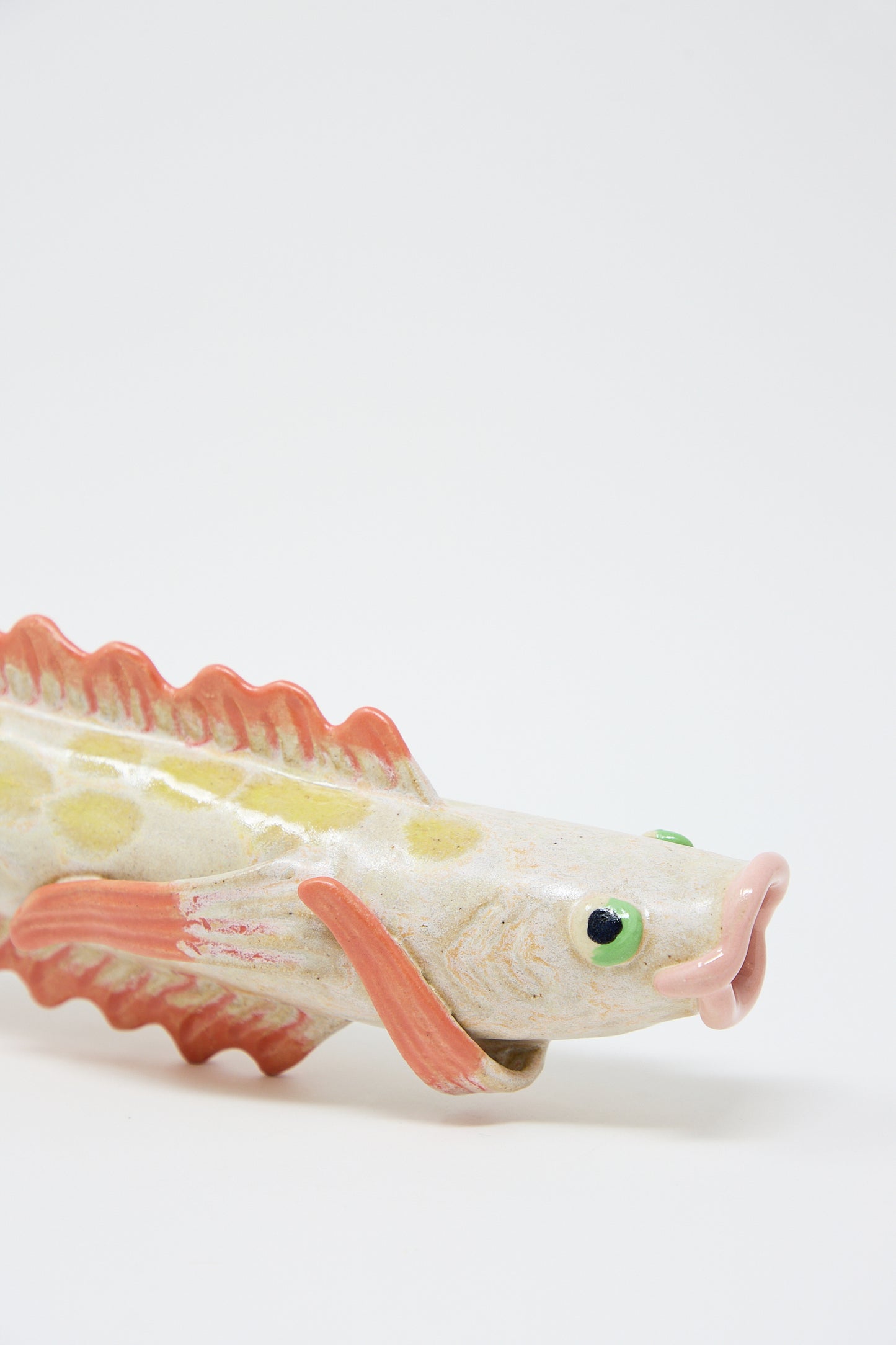 Pearce Williams Ceramic Fish Vase in Pink, with a colorful glazed finish, featuring pink fins and green eyes, isolated on a white background.