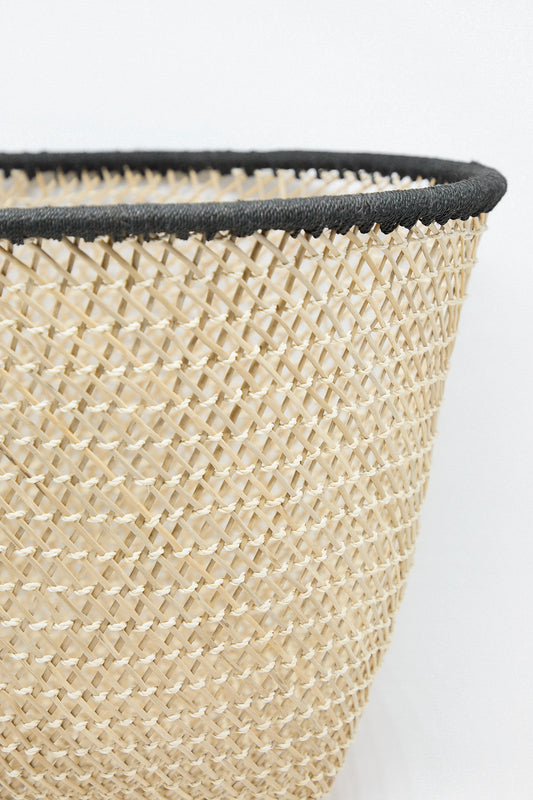 A Niga Open Weave Basket in Black with black trim on a white background, handcrafted by indigenous artisans in Colombia, made by Plaza Bolivar.