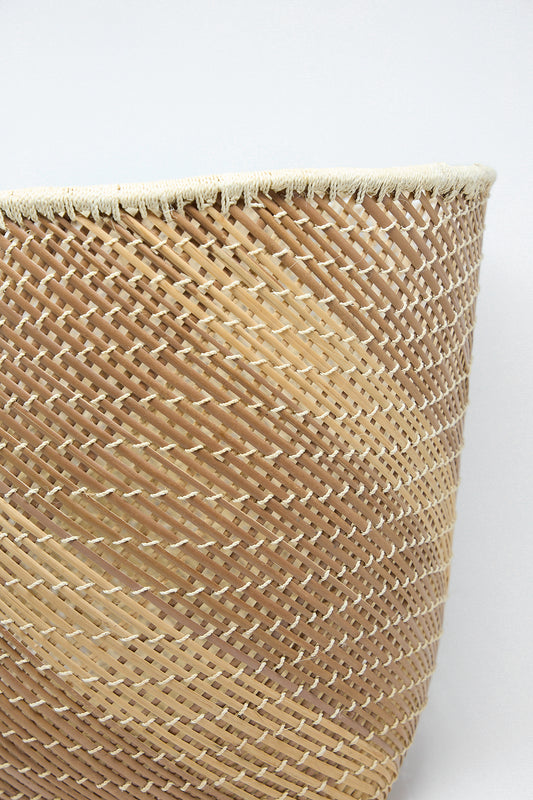 A Plaza Bolivar Niga Open Weave Basket in Natural on a white surface. Up close.