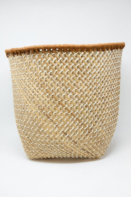 An open weave basket made of woven rattan, showcasing the traditional craftsmanship of an indigenous community from Latin America. The exquisite design stands out against a pristine white background. This beautiful piece is brought to you by Plaza Bolivar.