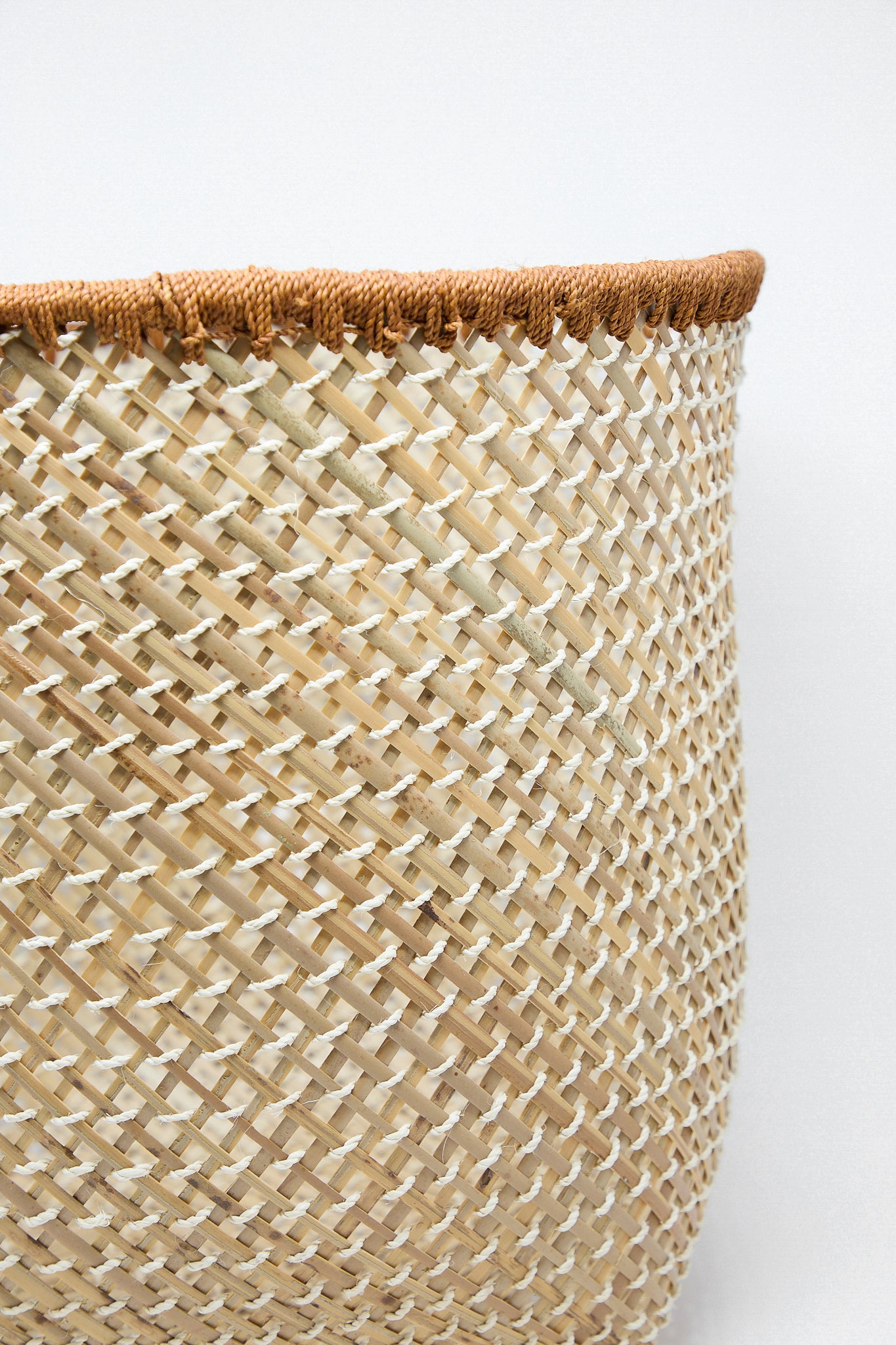 A Plaza Bolivar Niga Open Weave Basket in Rust, crafted by an indigenous community in Latin America, showcased on a white background.