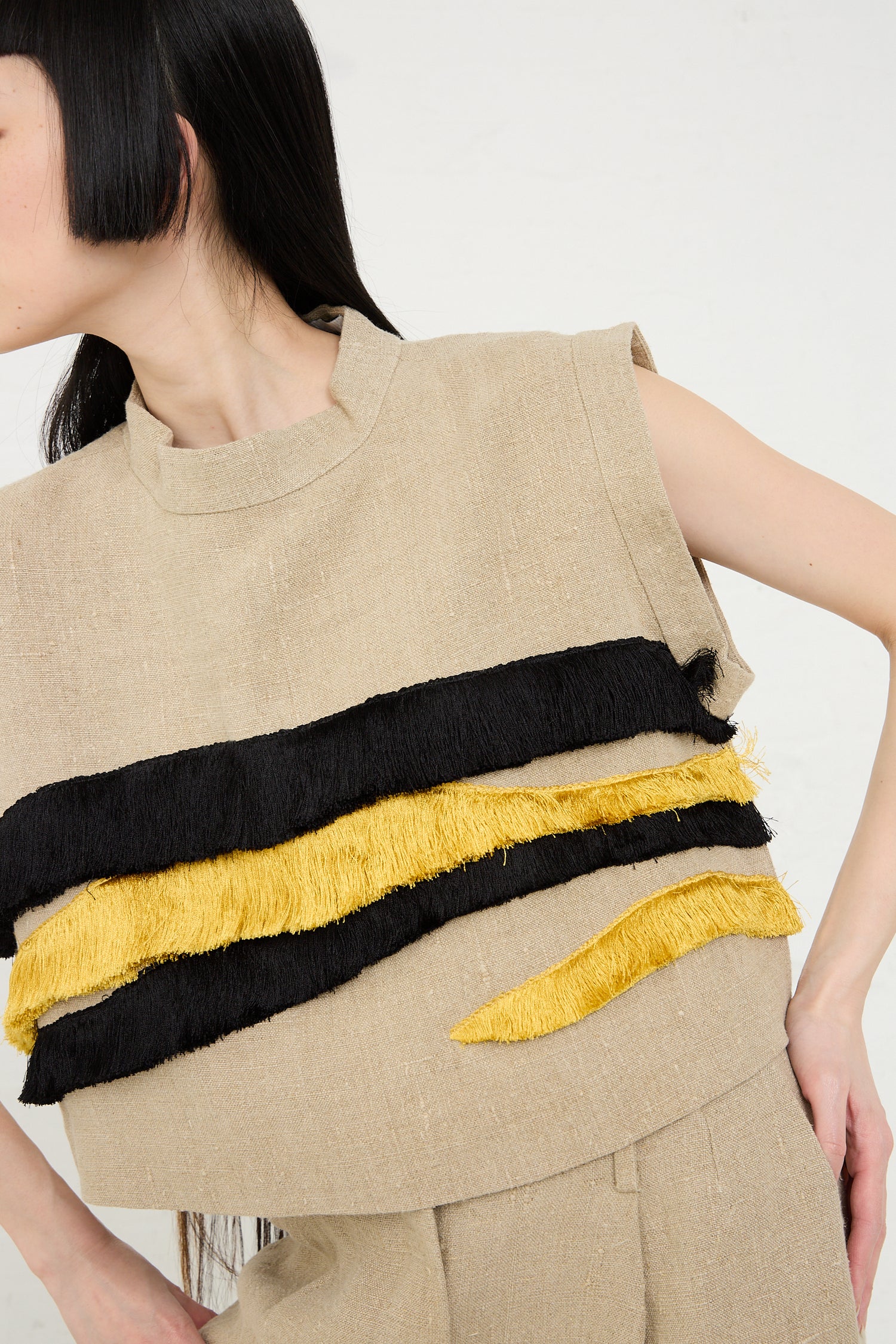 Woman wearing a Rachel Comey Bacchus Top in Natural with black and yellow textured stripes.