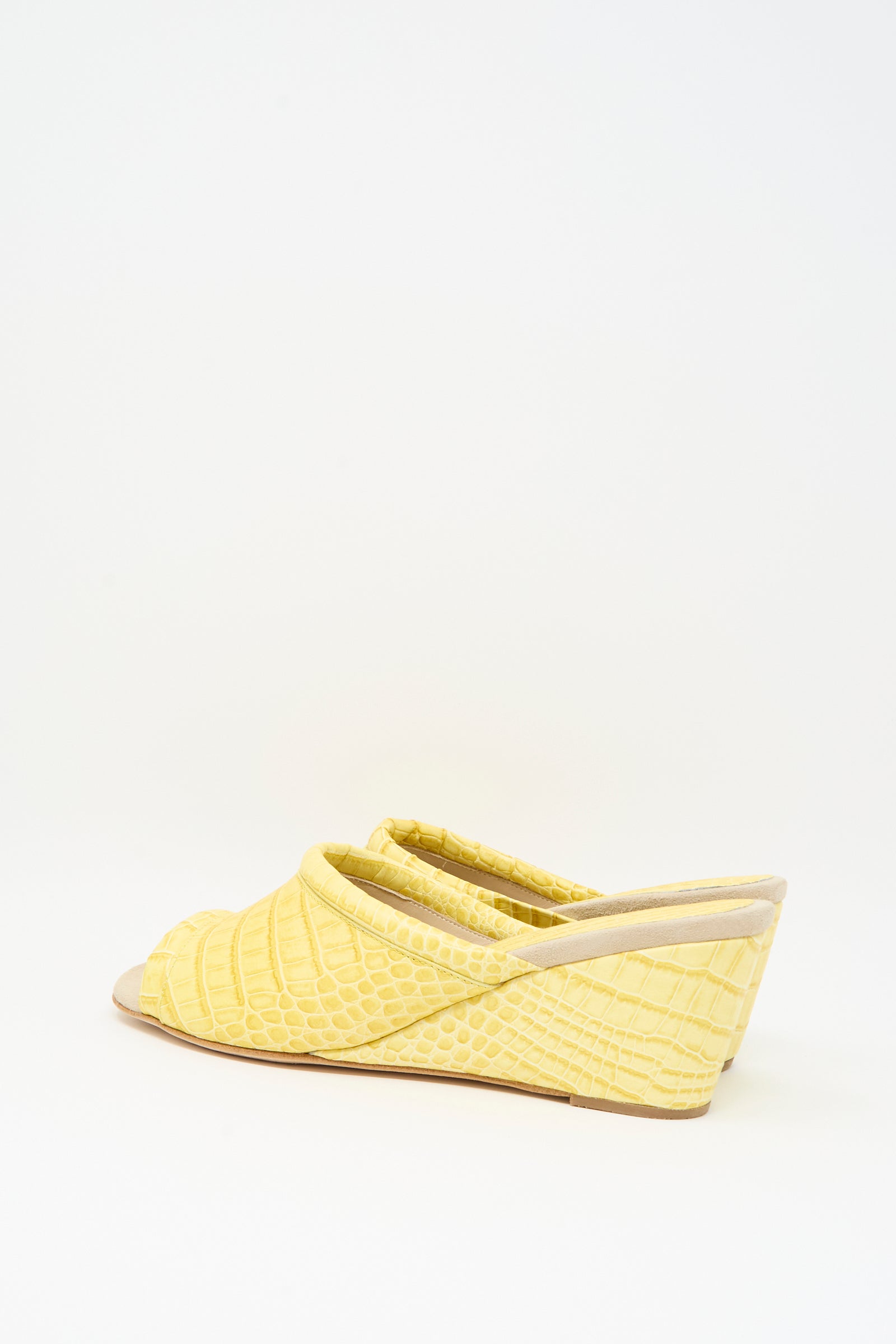 The Bully Mule in Banana by Rachel Comey is a yellow leather mule with an open-toe design and chic wedge heel, showcasing a textured snakeskin pattern reminiscent of crocodile skin, set against a plain white background.
