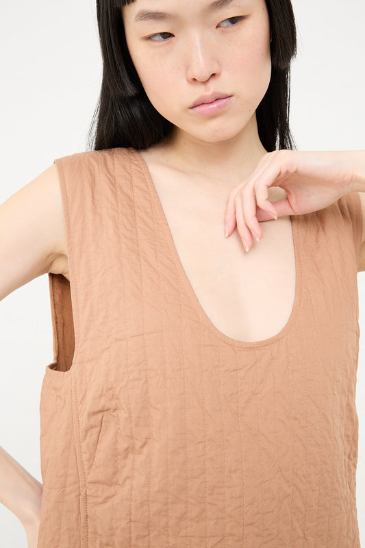 A woman wearing a sleeveless Calin Dress in Camel by Rachel Comey with a v-neckline.