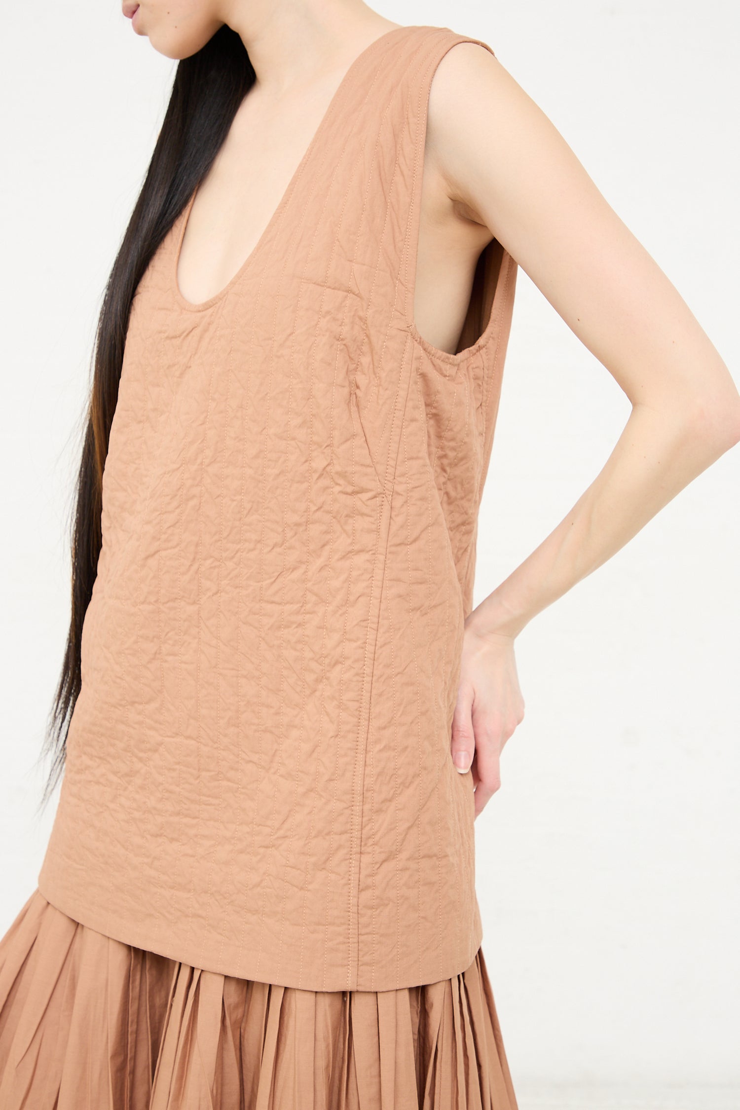 Woman wearing a sleeveless Rachel Comey Calin Dress in Camel with a textured fabric.