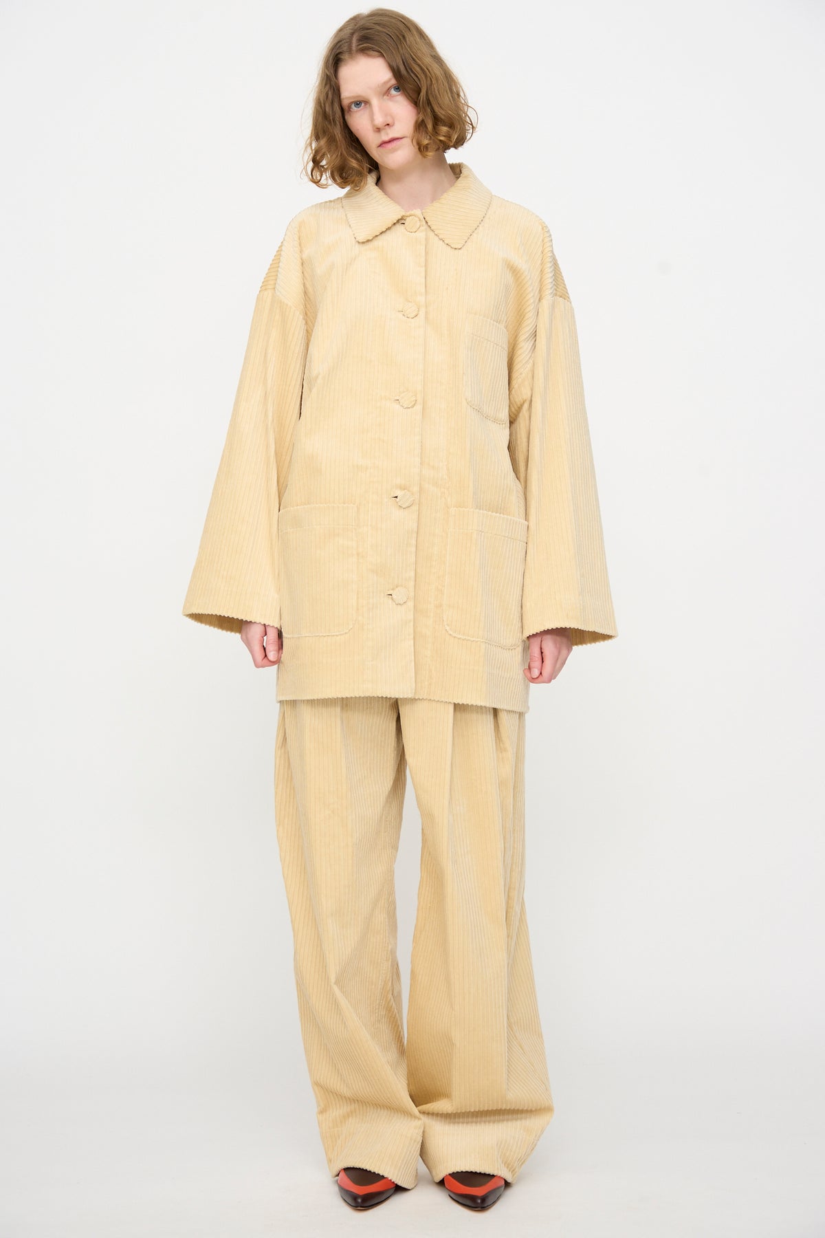 A person wearing the Rachel Comey Chore Jacket in Dune, styled with matching wide-leg pants, stands against a plain white background.