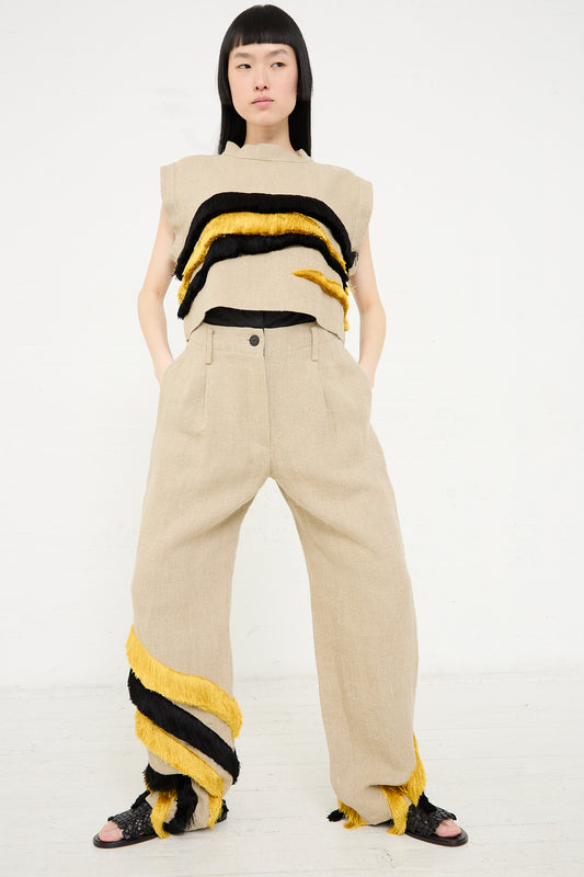 Woman posing in a sleeveless top with black and yellow stripes and Rachel Comey's Ditto Pant in Natural.