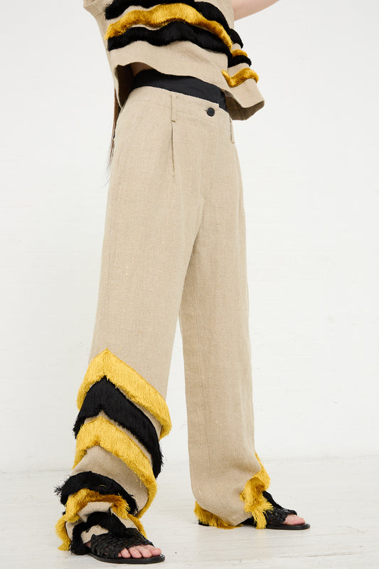 Woman wearing the Rachel Comey Ditto Pant in Natural with black and yellow fringe detail on the hem, paired with black sandals, from the Rachel Comey design and Joan Jonas collaboration.