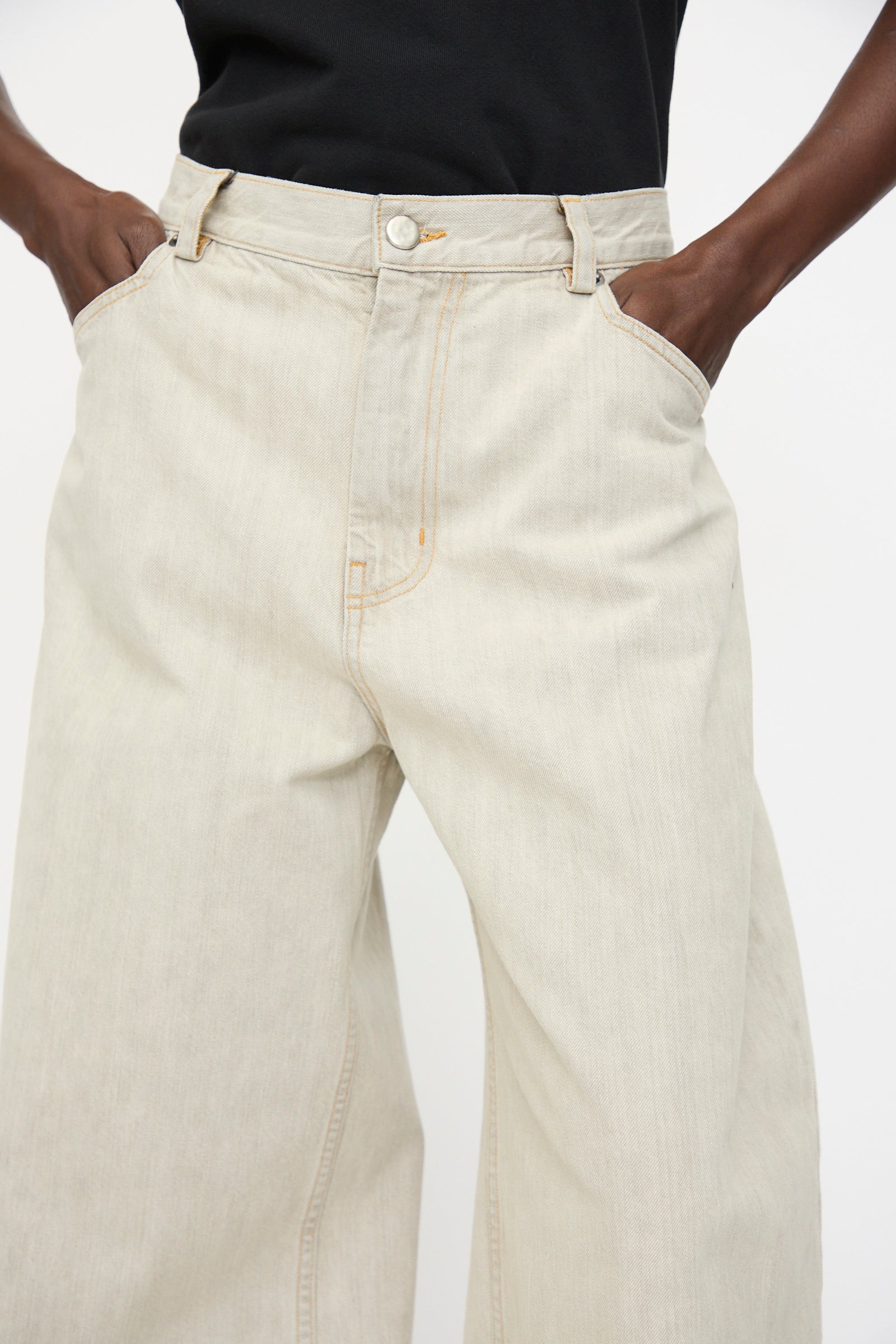 A person wearing the Rachel Comey Dottir Pant in Khaki Wash and a black shirt, hands in their pockets, shown from waist to mid-thigh.