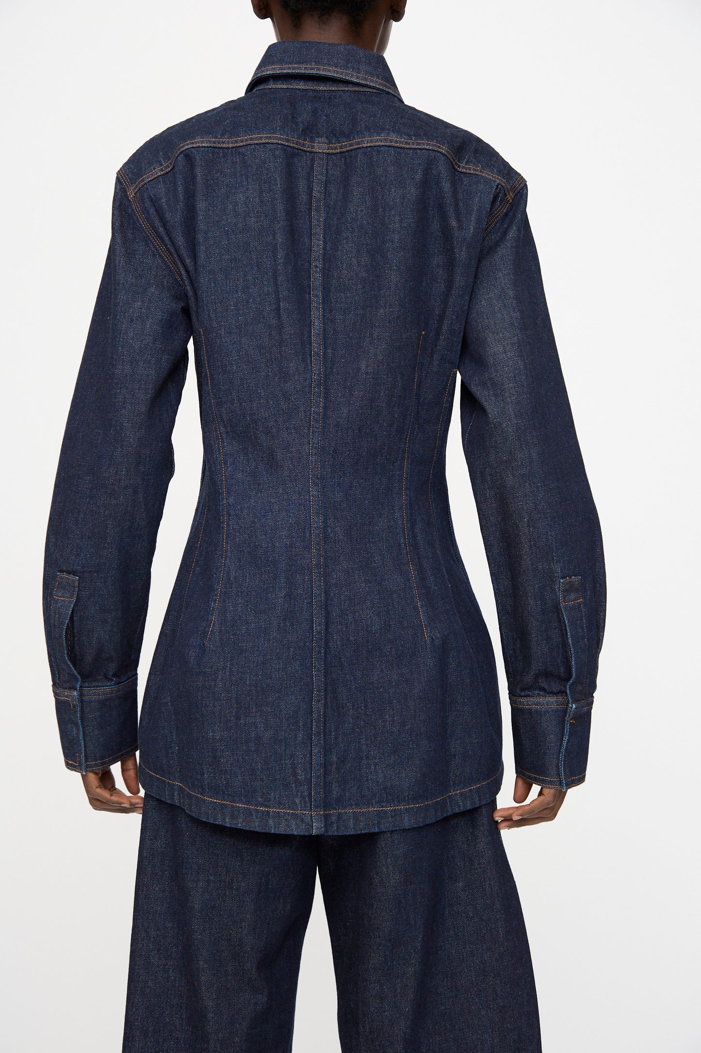 A person is shown from the back wearing the Rachel Comey Filt Top in Raw Wash, styled as a dark blue denim jacket with matching pants, against a plain white background.