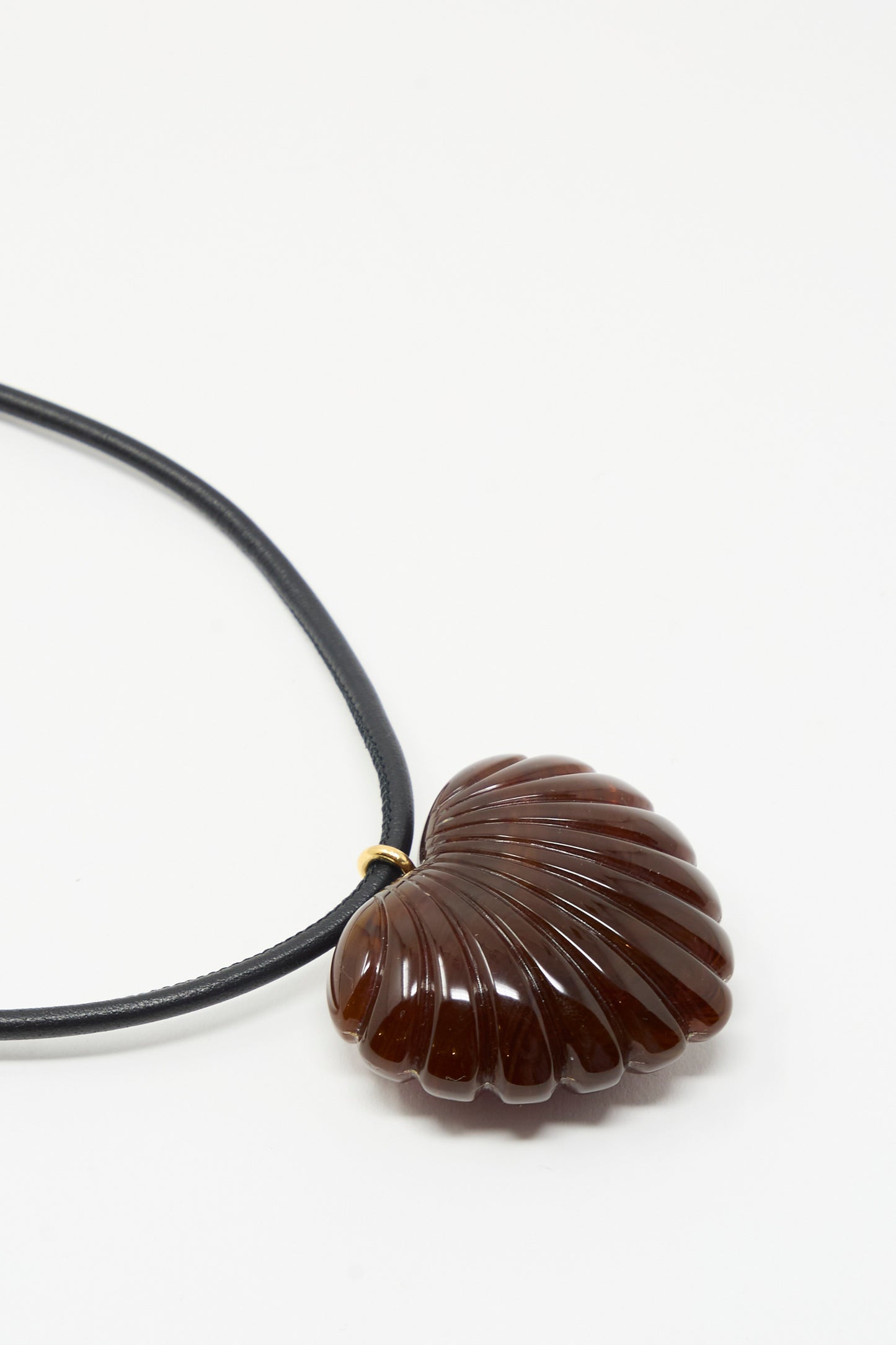 The Findon Necklace in Dark Tortoise by Rachel Comey features a shell-shaped, dark brown polished pendant on a black leather cord.