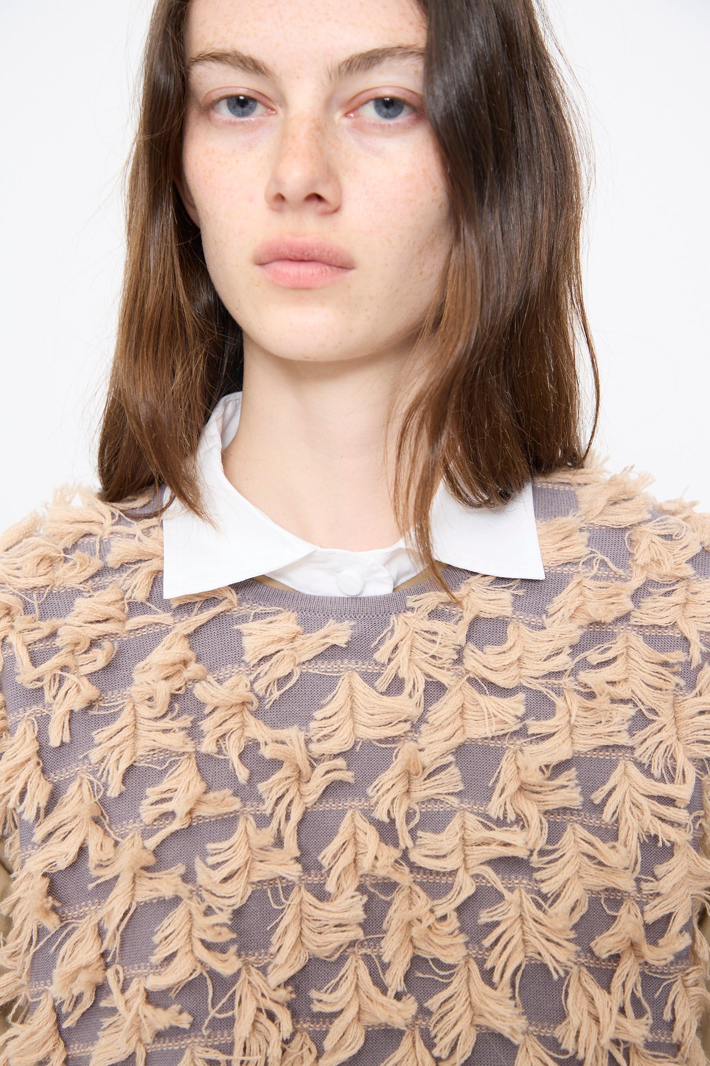 A woman with straight brown hair wears the Rachel Comey Hazlitt Top in Dusty Mauve-Blush over a collared white shirt, set against a plain light background.
