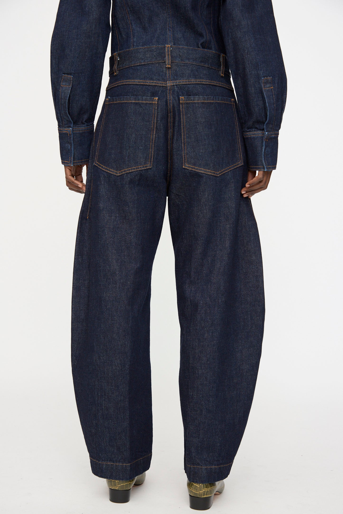 Model wearing the Rachel Comey Keenan Pant in Raw Wash denim, styled with a matching top, shown from the back against a plain white background.