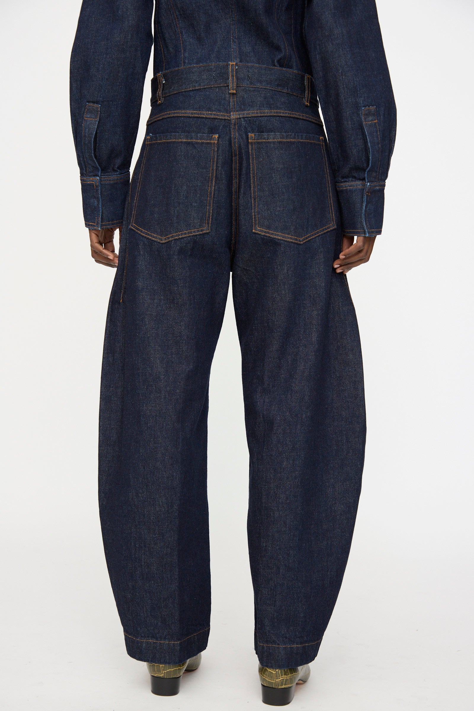 Model wearing the Rachel Comey Keenan Pant in Raw Wash denim, styled with a matching top, shown from the back against a plain white background.