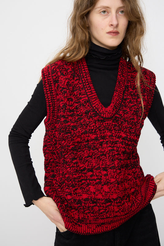 A person wearing the Rachel Comey Mati Vest in Red Marble, styled with a black turtleneck and relaxed fit, stands against a plain background.