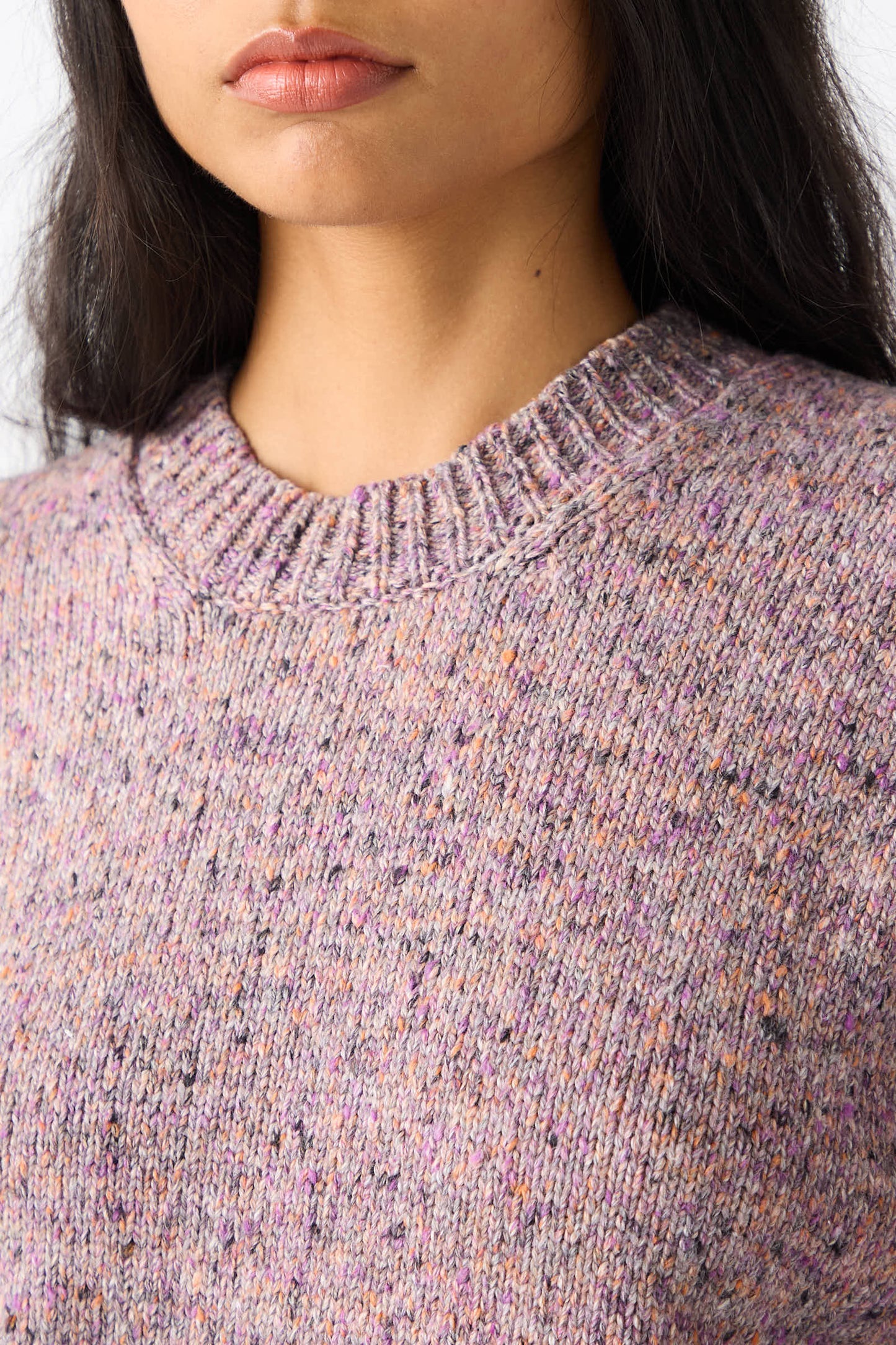 Close-up of a person wearing the Rachel Comey Neps Tweed Knit Ninni Sweater in Violet. Their lips and chin are visible, and they have long dark hair.