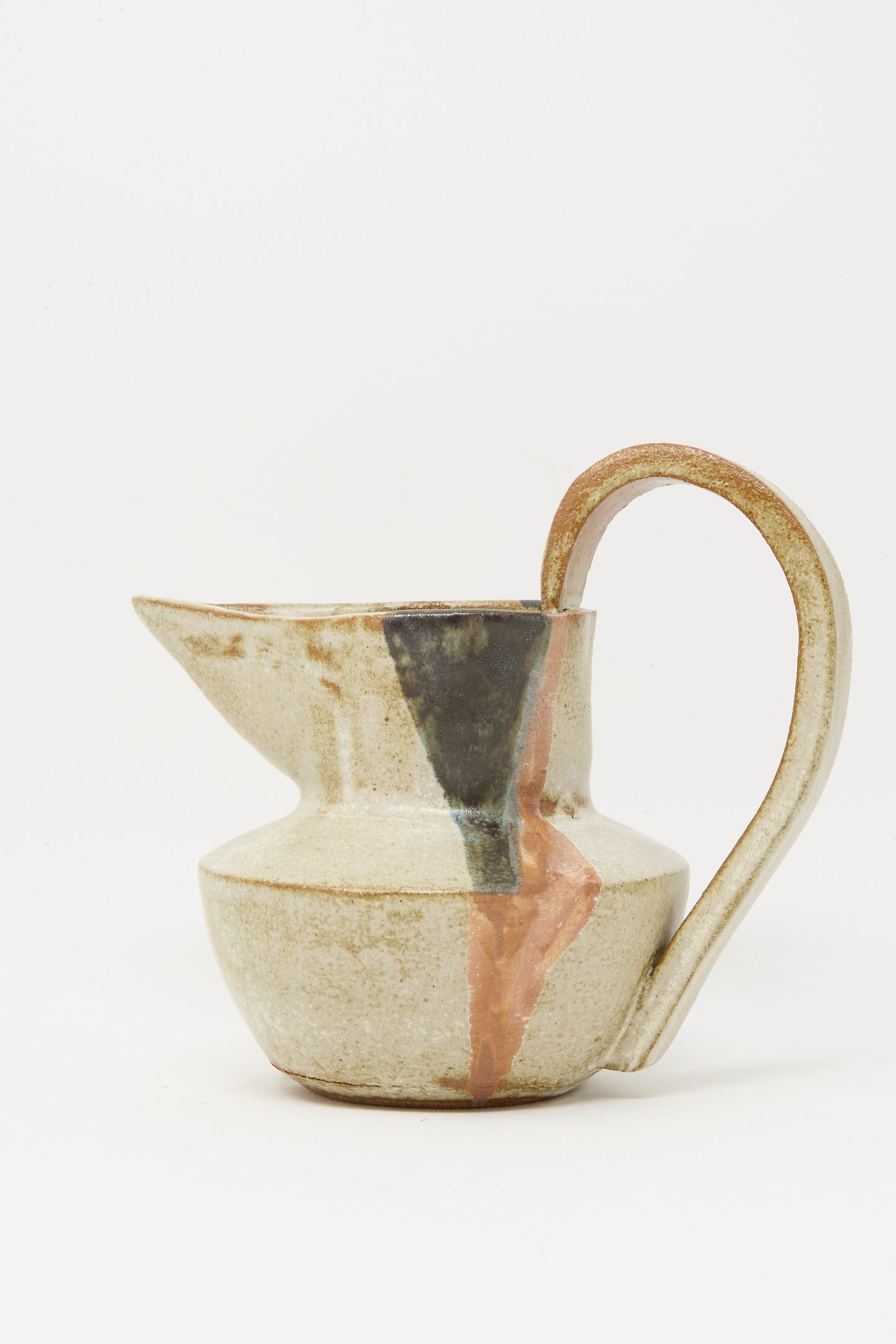 The Drawn Pitcher in Creme by Rachel Craven is a handmade, wheel-thrown clay pitcher with a large handle, visible gold and copper-filled repaired cracks, and a mineral glaze finish set against a white background.