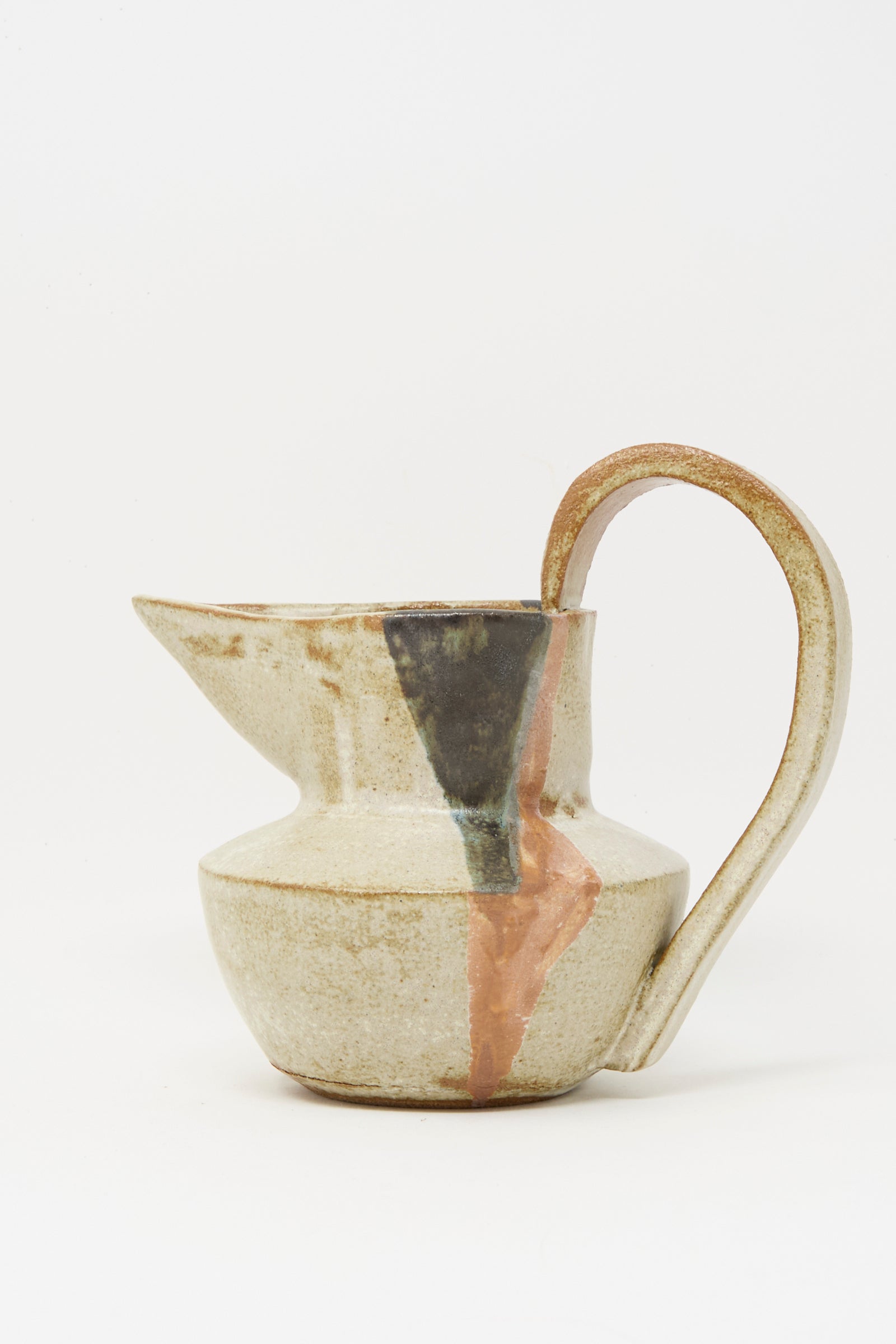 The Drawn Pitcher in Creme by Rachel Craven is a handmade, wheel-thrown clay pitcher with a large handle, visible gold and copper-filled repaired cracks, and a mineral glaze finish set against a white background.