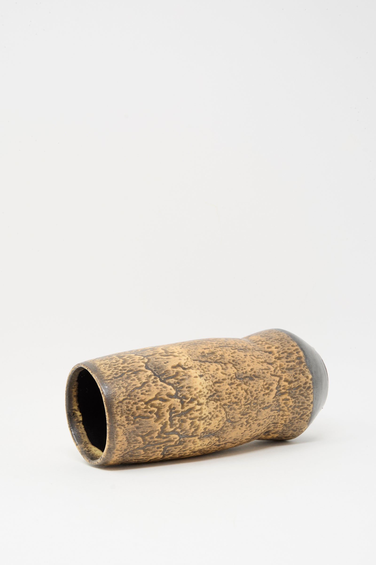 The Tall Sap Vase in Brown by Rachel Craven is a cylindrical, textured, wheel-thrown clay vase with a slightly tapered shape, shown lying on its side against a plain white background.