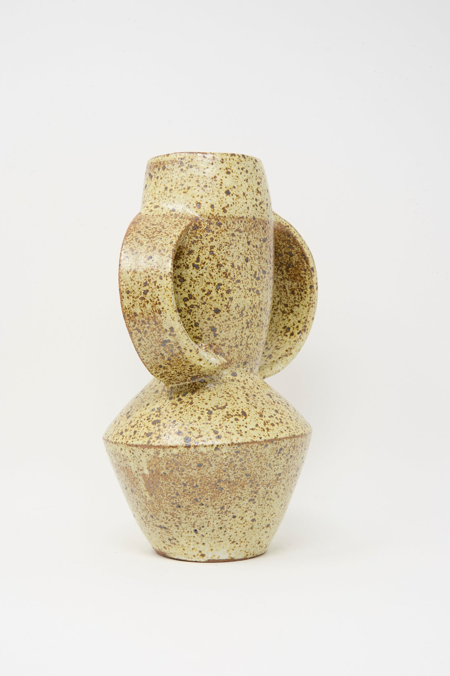 The Tall Shaped Handled Vase in Eggshell Speckle by Rachel Craven features a geometric, abstract form with two rounded handles and an angular base, shown against a plain white background.