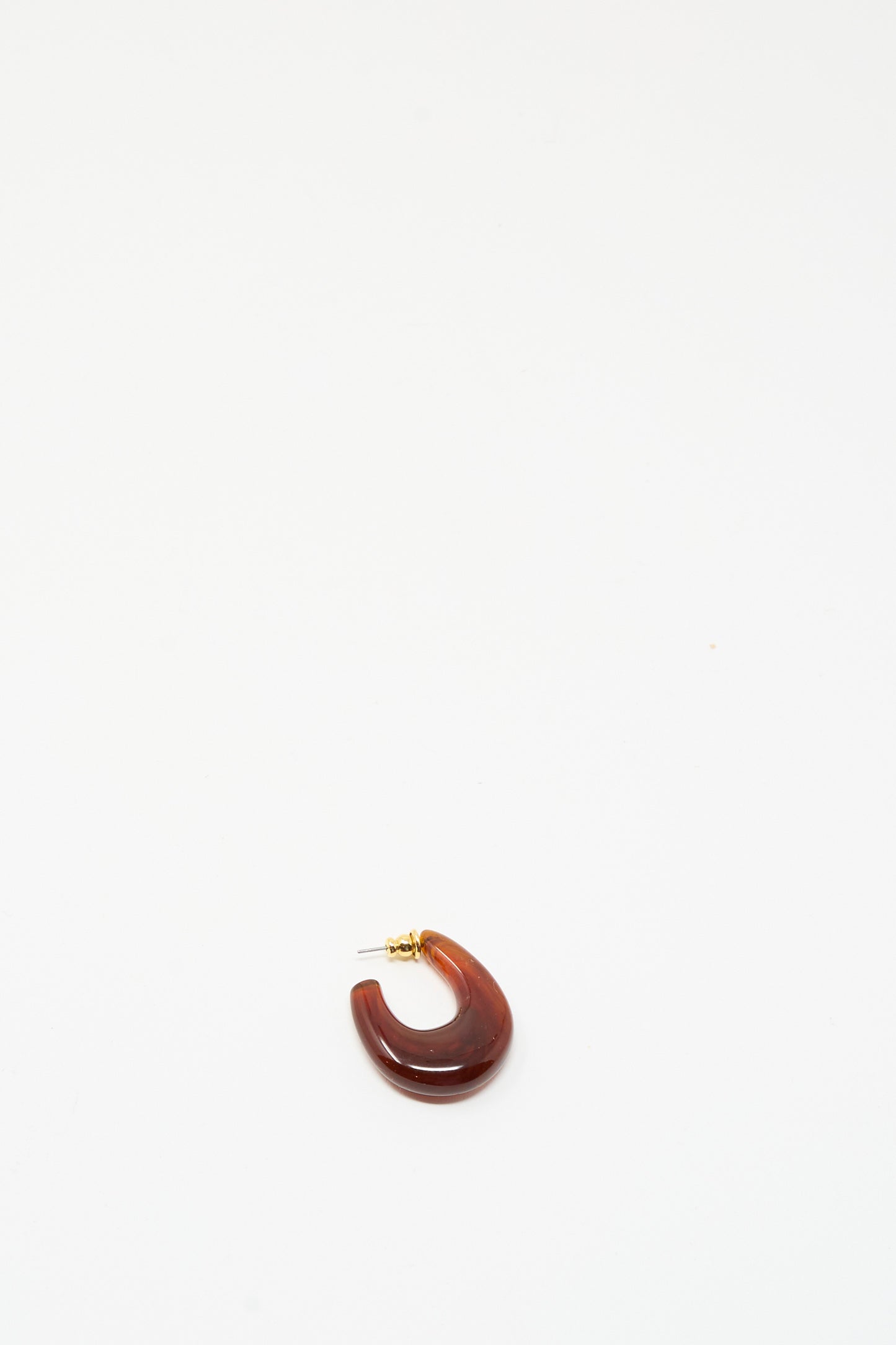 The Isle Earring in Dark Tortoise by Rachel Comey is a single chunky hoop earring crafted from dark tortoise marbled acrylic with a gold stud backing, shown against a plain white background.