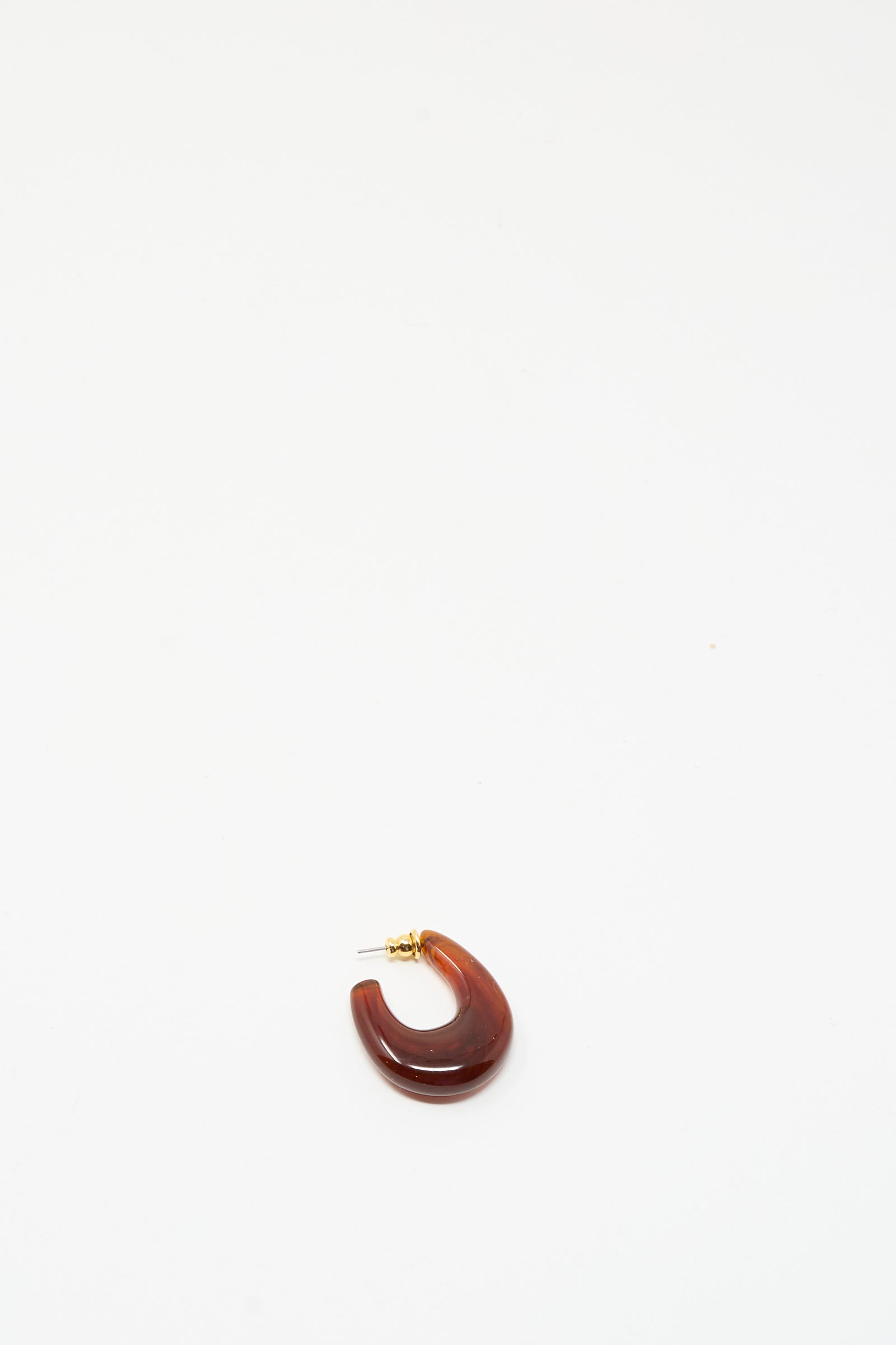 The Isle Earring in Dark Tortoise by Rachel Comey is a single chunky hoop earring crafted from dark tortoise marbled acrylic with a gold stud backing, shown against a plain white background.