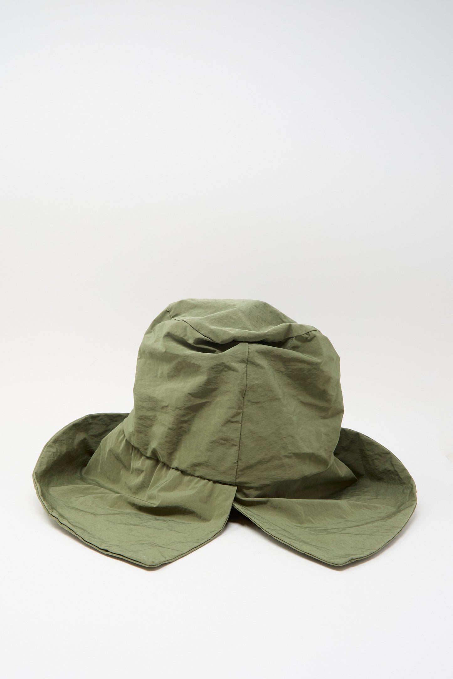 The Bianca Hat in Green by Reinhard Plank is a wide-brimmed cotton visor with a wrinkled texture, shown on a plain white background.