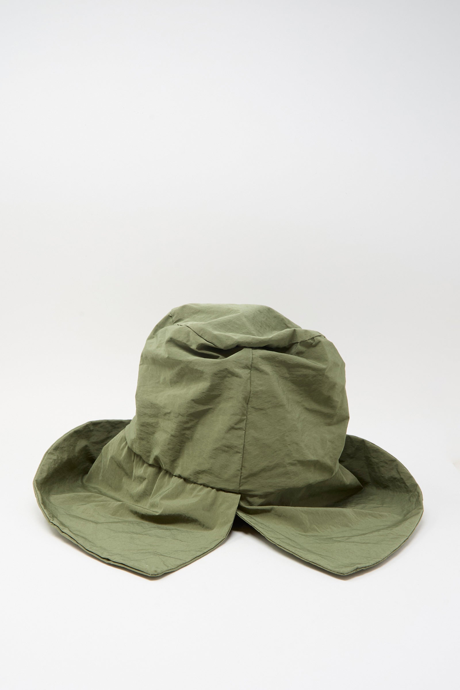 The Bianca Hat in Green by Reinhard Plank is a wide-brimmed cotton visor with a wrinkled texture, shown on a plain white background.