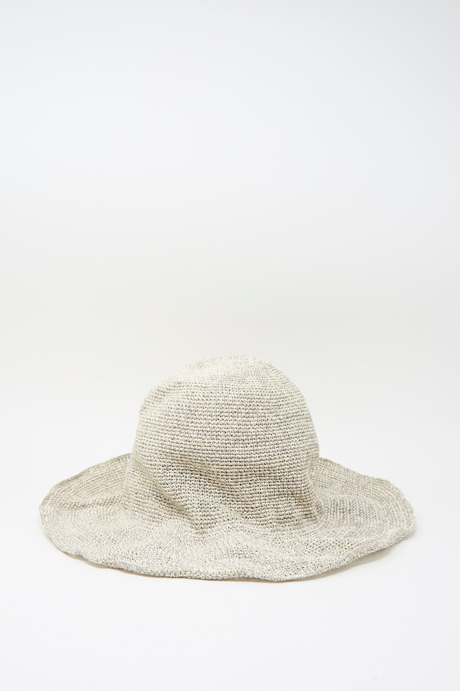 The Isle New Paper Hat in White, Sand by Reinhard Plank is a wide-brimmed crocheted hat made in Italy, shown against a plain white background.