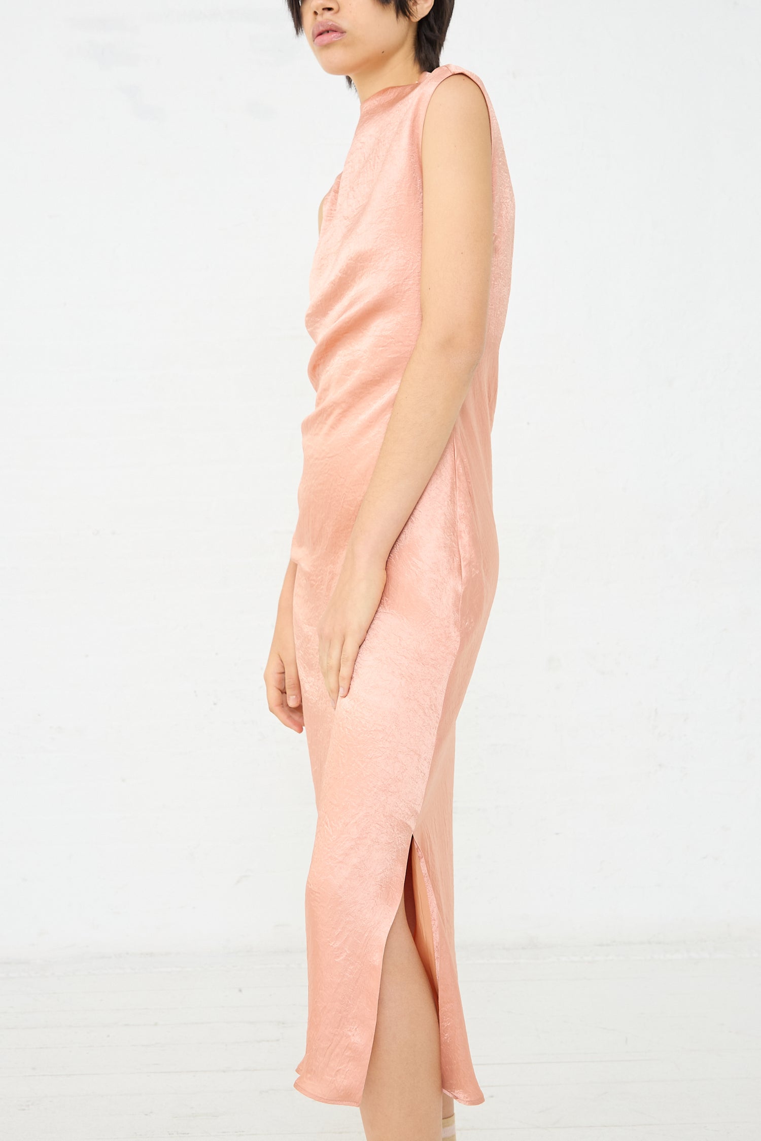 A woman wearing a Rejina Pyo Delilah Dress in Pink. Full length and side profile view.