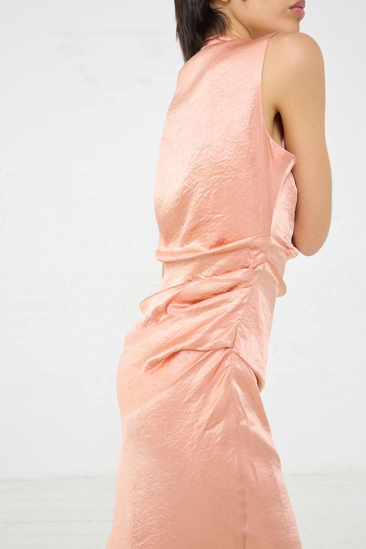 A woman is posing in a Rejina Pyo Delilah Dress in Pink. Side view.