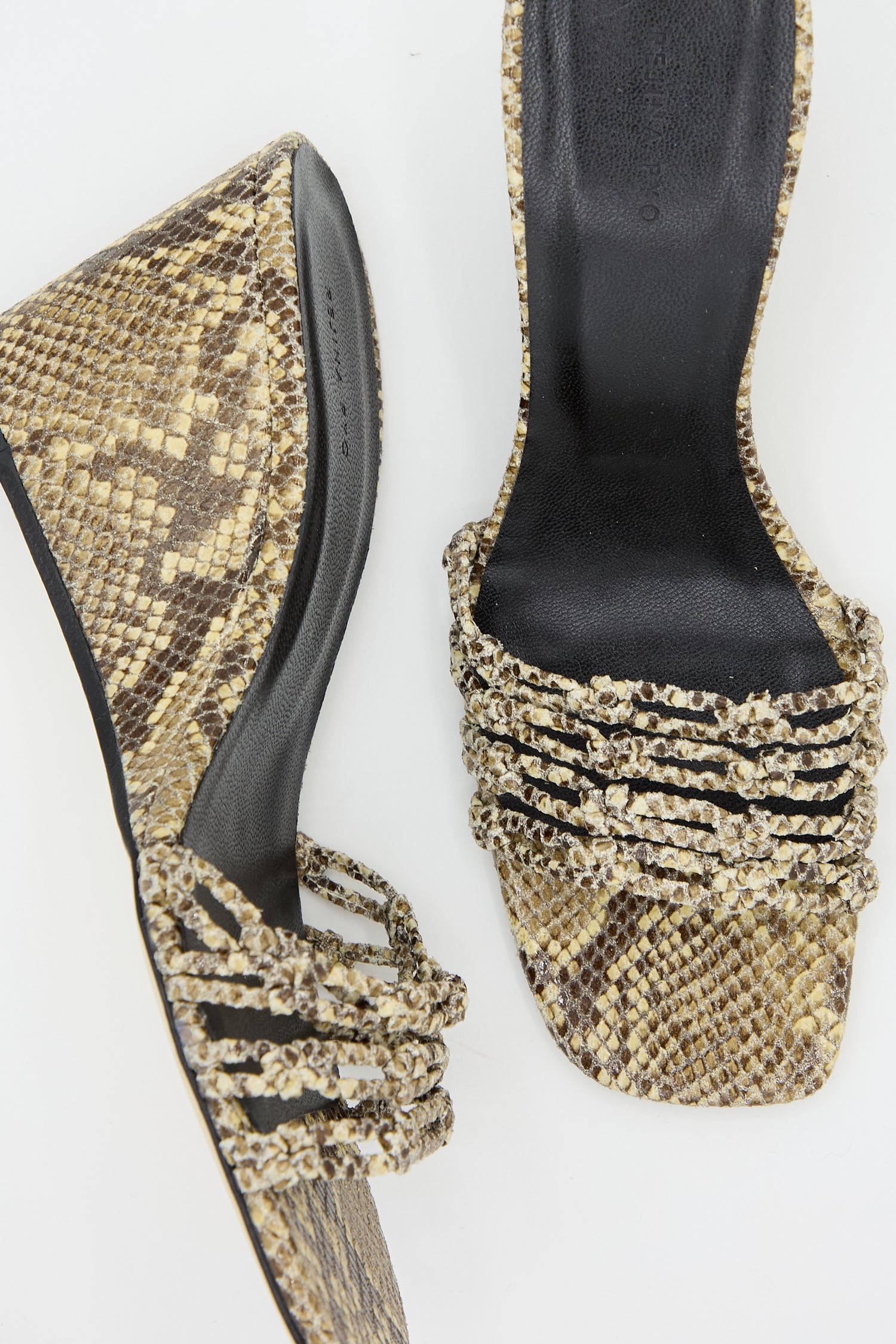 Pair of high-heeled shoes with Rejina Pyo Leather Print Kyle Wedges in Snake Butter and ruffled details.