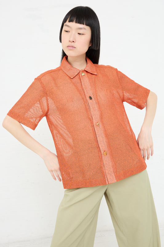 Woman modeling a short-sleeved Mesh Stripe Marty Shirt in Orange with khaki pants against a plain background, adding a touch of sophistication with a Rejina Pyo boxy silhouette.