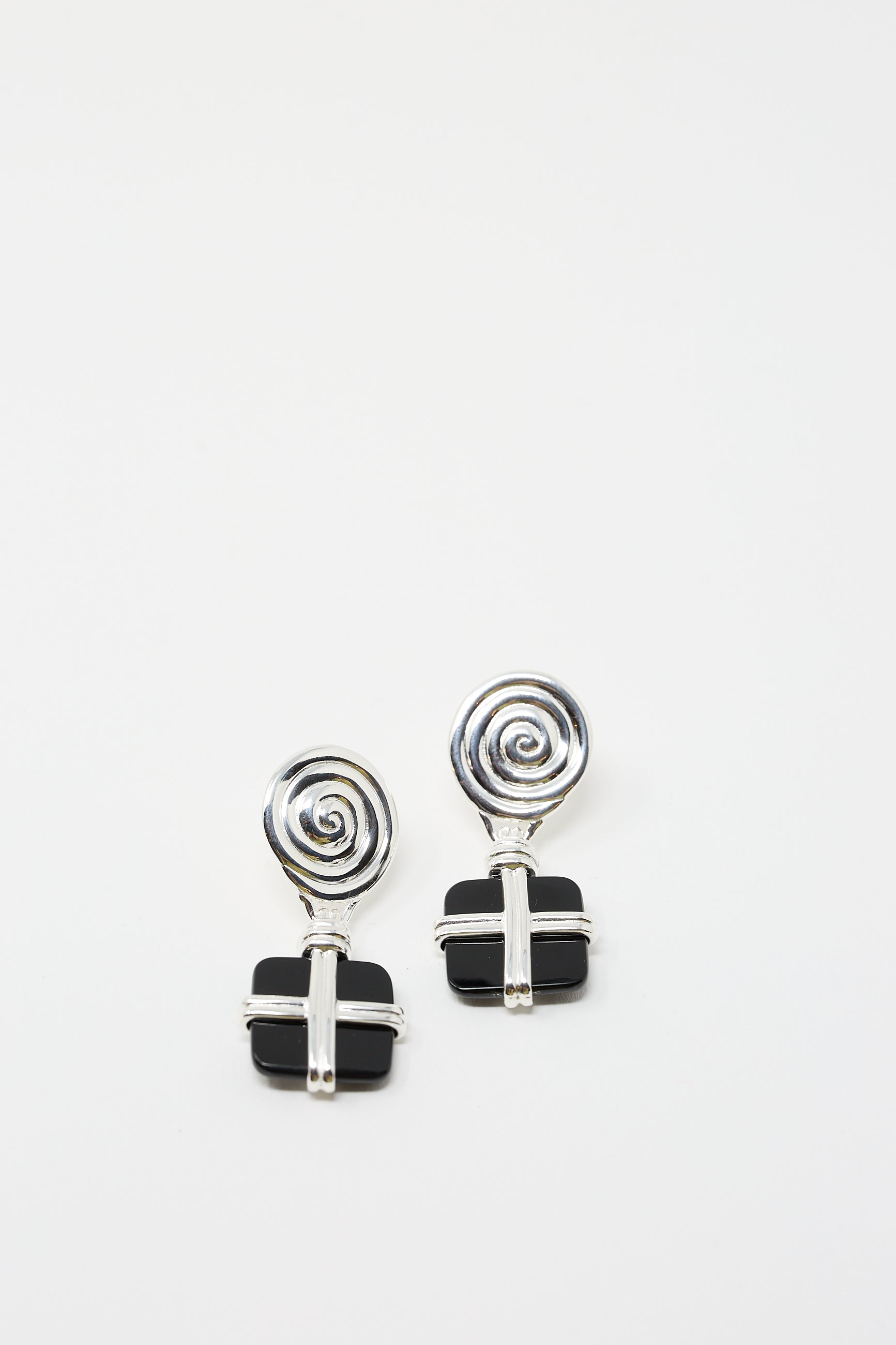 A pair of Rejina Pyo's Silver Plated Squiggle Earrings with Black Onyx, showcasing a spiral design at the top and a black onyx cross-shaped detail at the bottom, set against a plain white background.