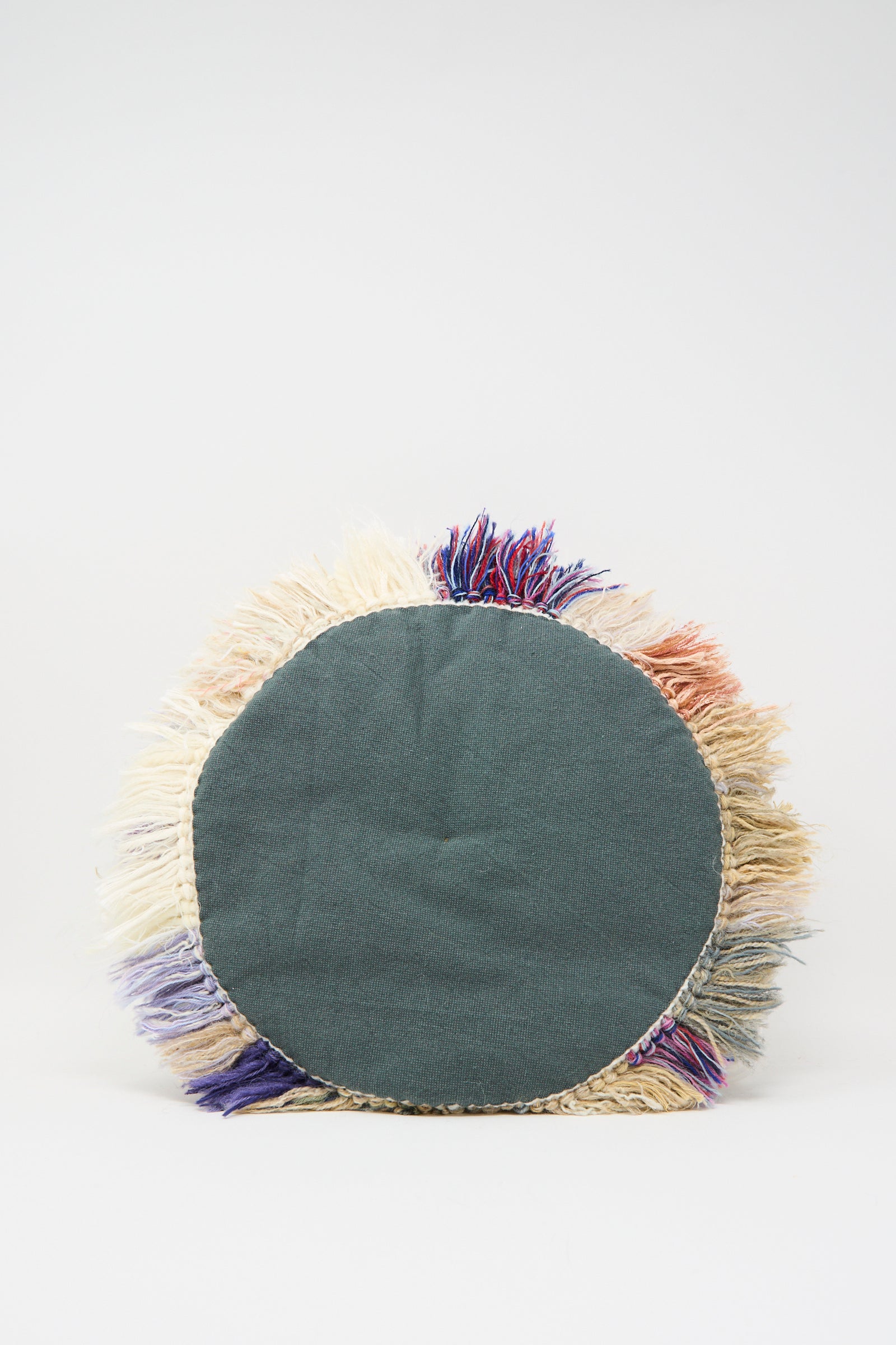 Renilde De Peuter's Handmade Cushion in Multi V features a solid dark green center with multicolored fringe, crafted from recycled yarns and shown against a plain white background.