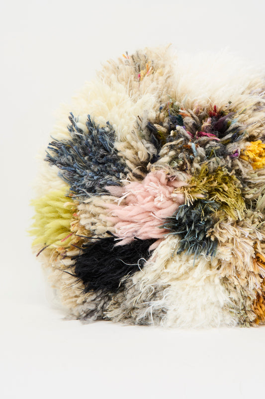 A close-up of the Handmade Cushion in Multi XII by Renilde De Peuter, featuring a multicolored, fluffy, textured surface made from recycled yarns, set against a plain white background.