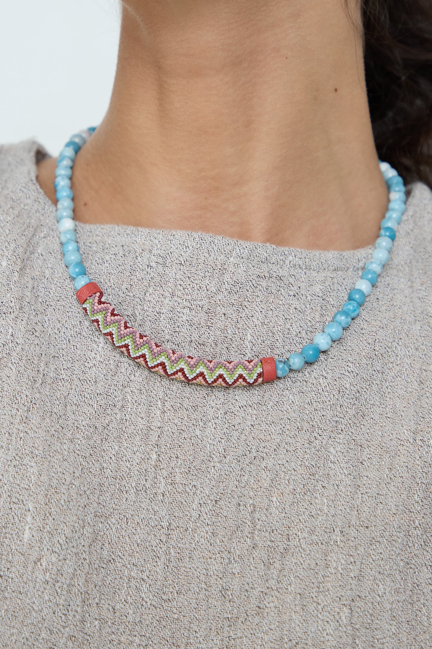 A chic Beaded Bar Necklace in Larimar adorned with Robin Mollicone beads, showcasing a contemporary sensibility.