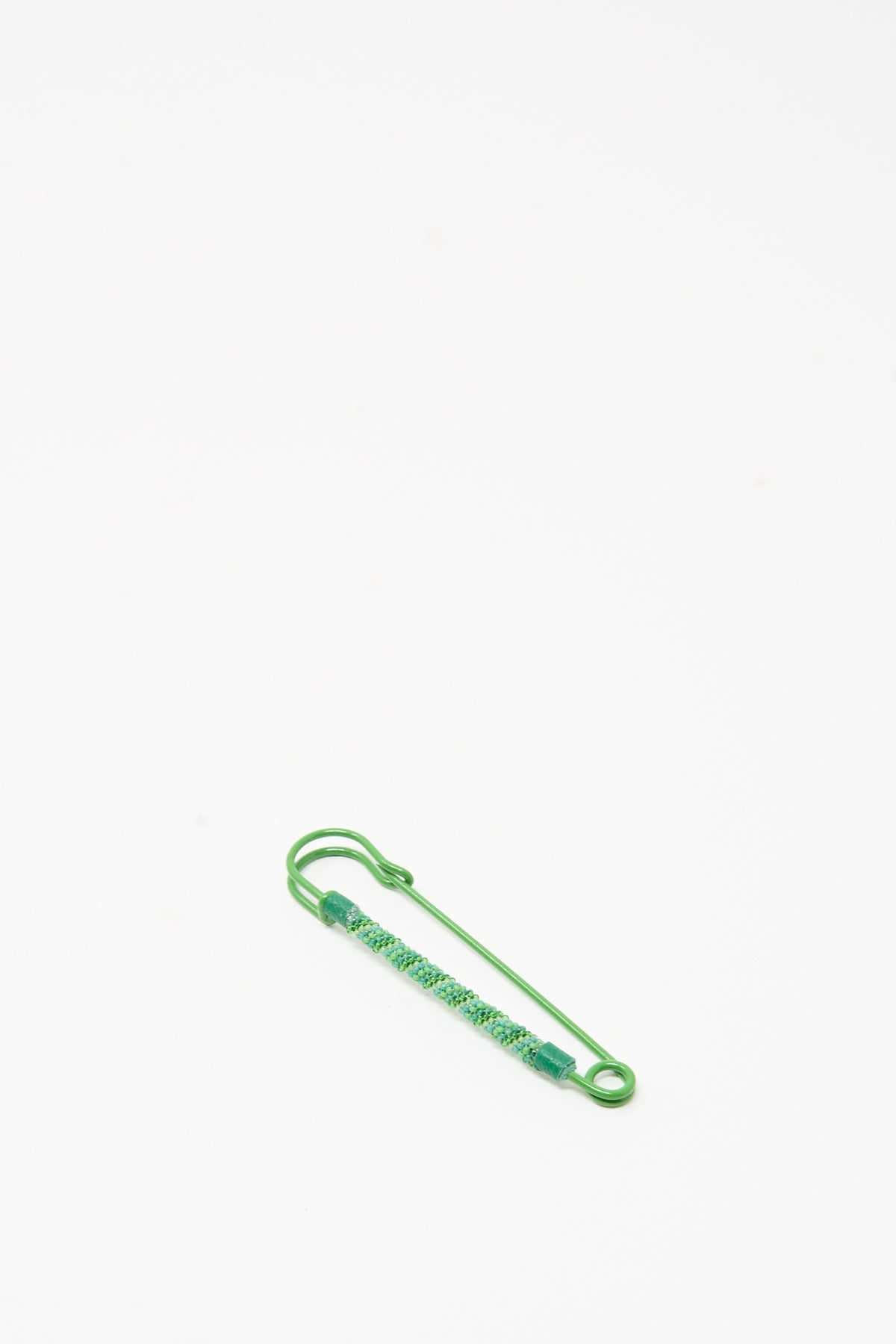 Robin Mollicone Beaded Safety Pin in Green, a color-coated steel safety pin partially covered with teal and green glass beads.