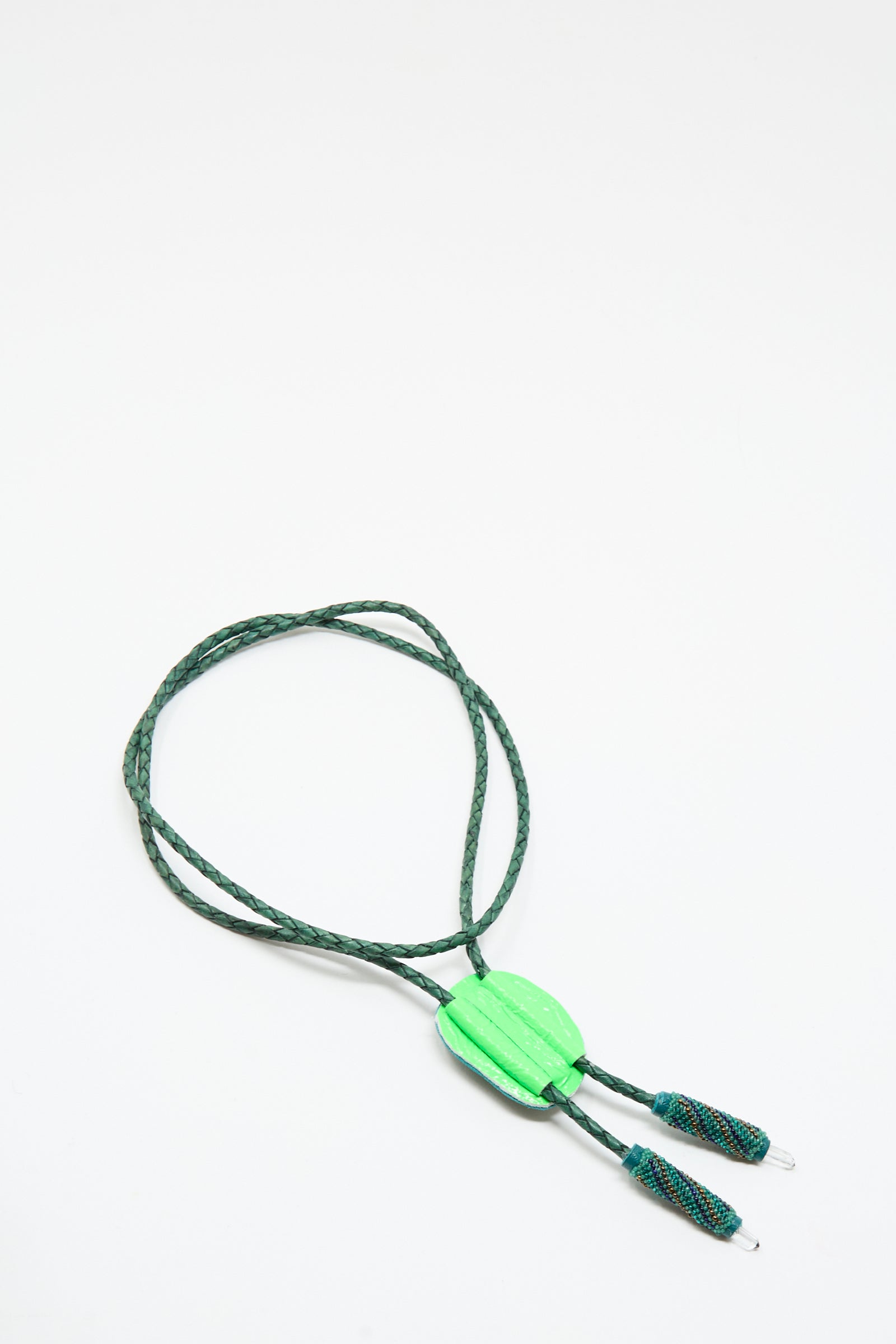 The Robin Mollicone Bolo Necklace in Apatite and Quartz features a green braided cord, a vibrant oval pendant, and two beaded ends, inspired by the classic bolo tie and shown on a white background.