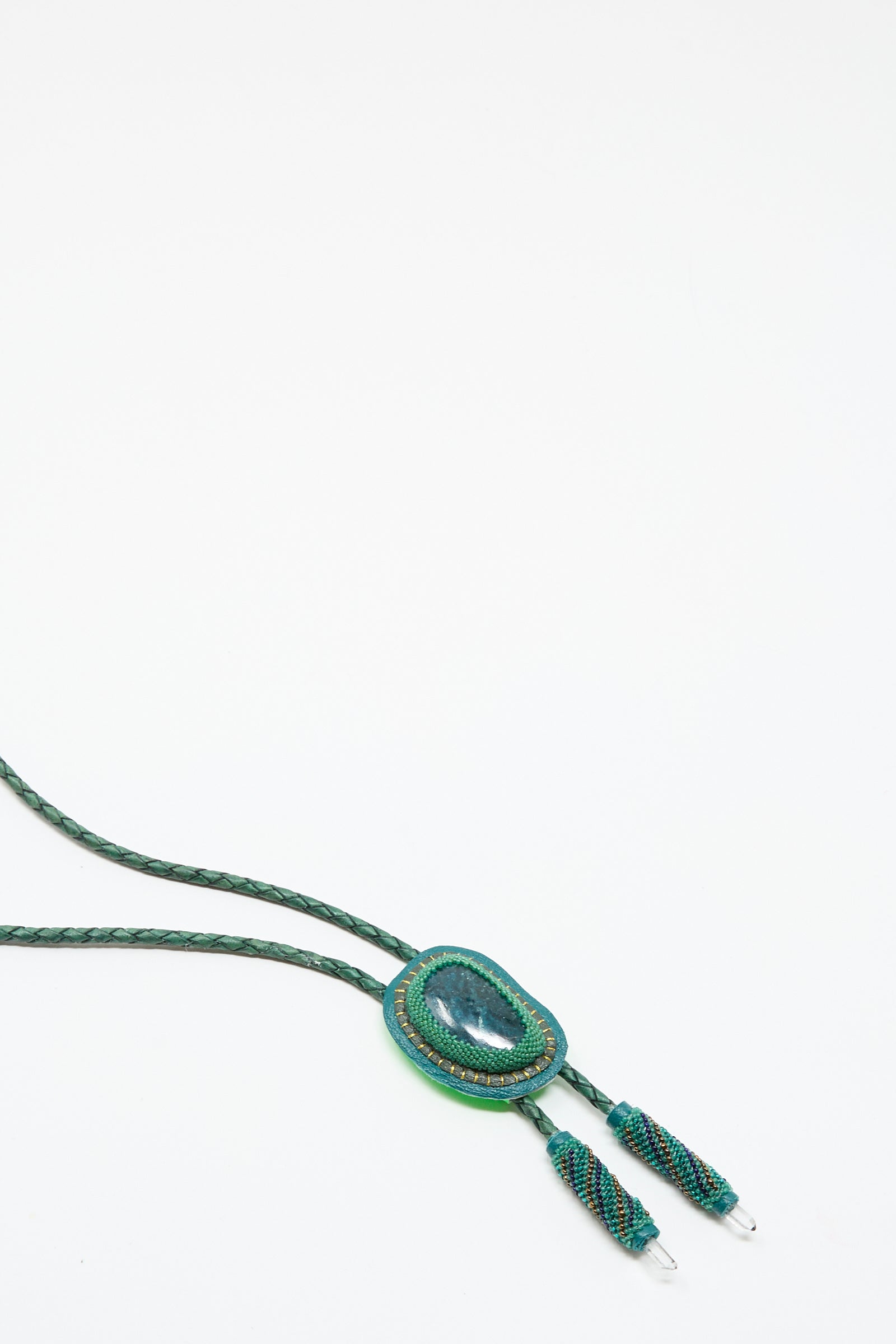 The Robin Mollicone Bolo Necklace in Apatite and Quartz features a green braided cord, a large oval Apatite gemstone pendant, and two decorative ends, shown on a white background.