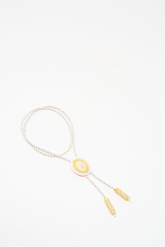 The Robin Mollicone Bolo Necklace in Mother of Pearl and Quartz features a yellow oval center, decorative gold-tone tips, subtle Mother of Pearl accents, and is handmade in NYC, shown on a white background.
