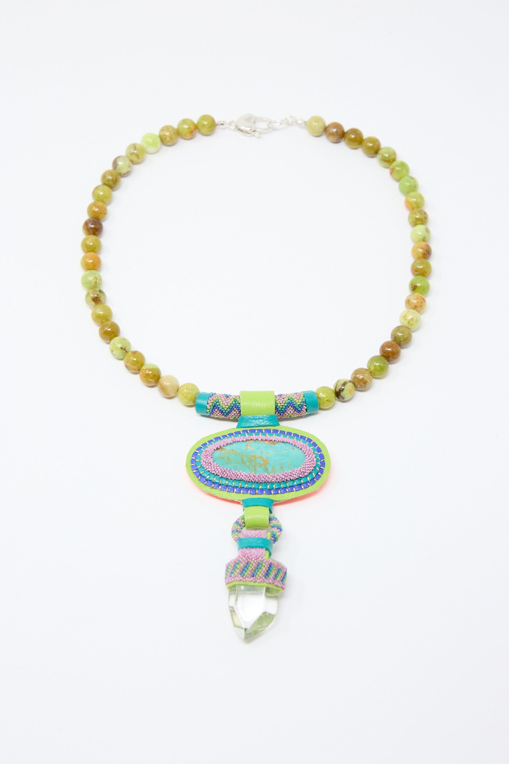 A Robin Mollicone Double Stone Necklace with Crystal, Olive Opal Beads and Turquoise Stone, featuring an intricate pendant with a colorful embroidered oval and a clear crystal hanging from it.