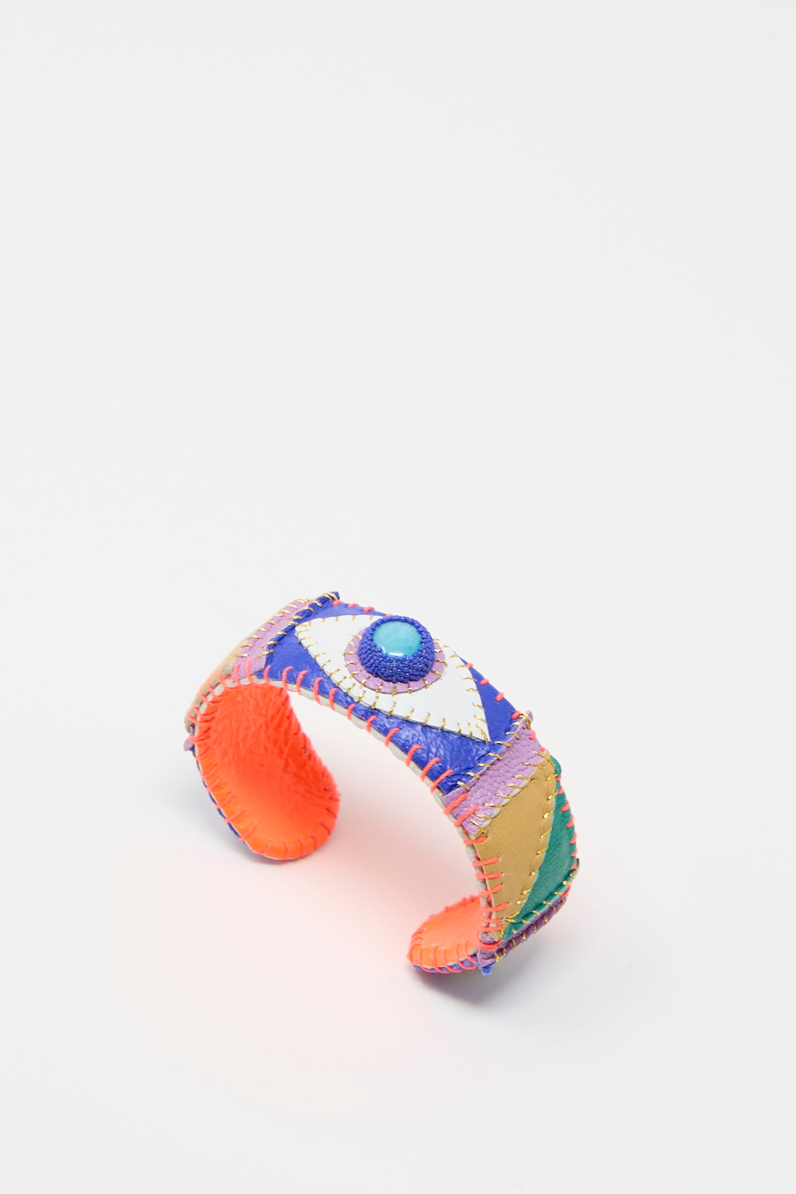 Introducing the Eye Cuff in Amazonite by Robin Mollicone: a vibrant, handmade bracelet showcasing an eye design with sections of purple, orange, green, and yellow on a white background. This exquisite piece evokes the charm of a patchwork leather cuff, infusing your look with bohemian elegance.